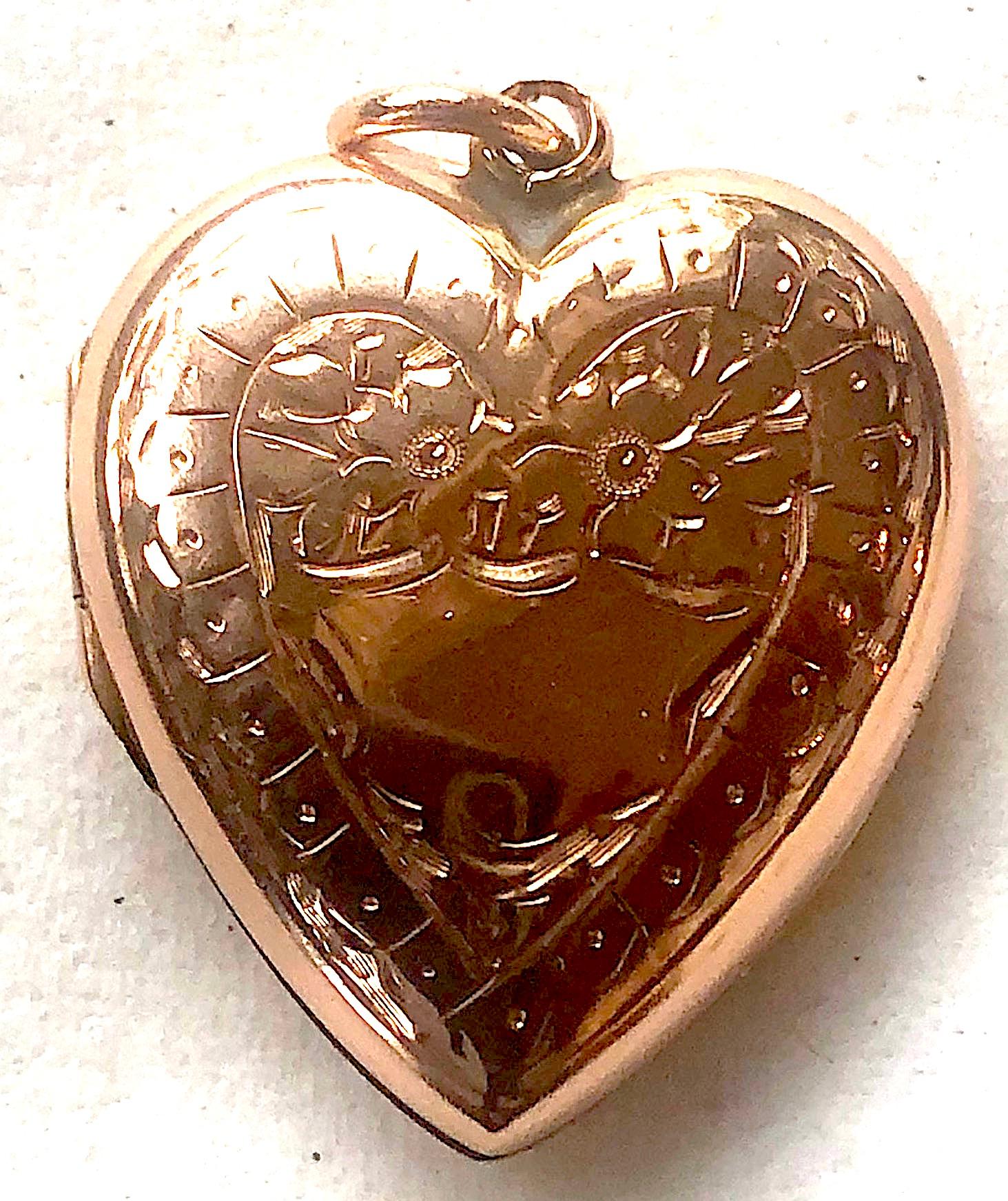 Antique 9K locket in the shape of a heart, with the original daguerreotype photos inside. Both sides are of 9K  as is the attached gold bale. There is a ring attached to the bale to hang the locket from a chain. On the one side has a scene of what