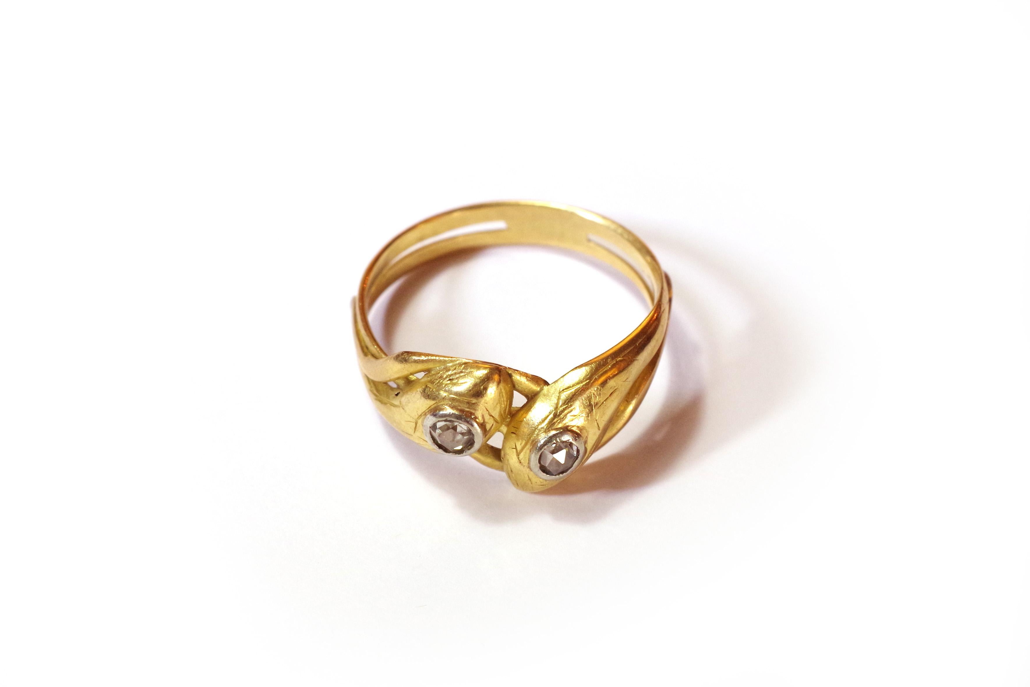 Victorian double snake ring in yellow gold 18 karats and silver. This ring is made by two snakes wrapping around the finger. The heads of the two reptiles are surmounted by a Dutch rose-cut diamond. The heads are delicately chiselled and come to