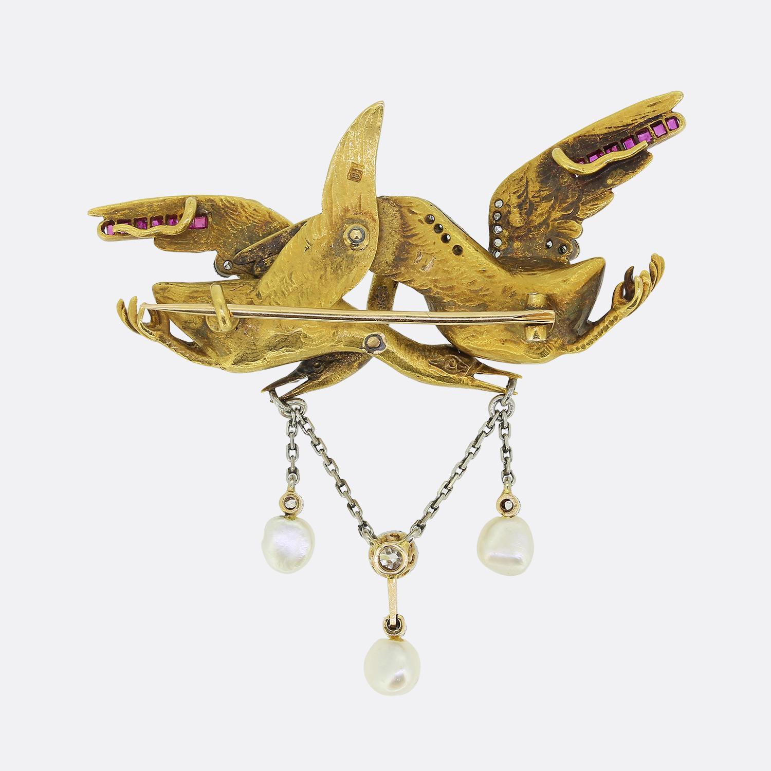 Here we have a wonderfully detailed brooch dating back to the Victorian era. This antique piece has been crafted from a rich 18ct yellow gold into the shape of two crossover stork birds. The features of these famous folklore birds have been