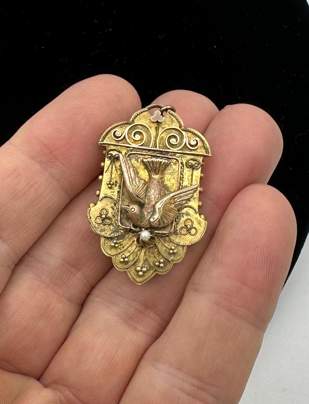 Dies ist eine wunderschöne und seltene antike viktorianische Vogel Taube Medaillon Anhänger Brosche in 10 Karat Gold mit einer Perle Tropfen in einem außergewöhnlichen Etruscan Revival dreidimensionalen Design mit dem fliegenden Vogel geschmückt. 