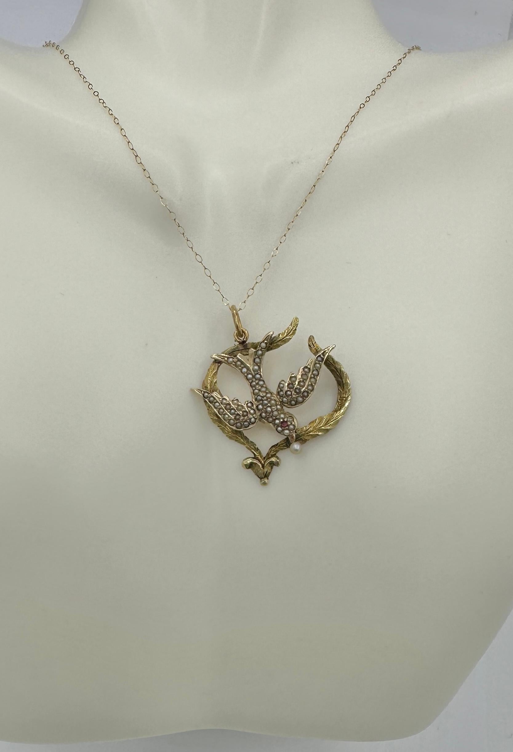 This is a gorgeous antique Victorian Dove Swallow Bird of Peace Pendant Necklace adorned with a Pearl in it its mouth, a Ruby eye, and seed pearls throughout creating the white feathers of the dove.  The lavaliere pendant has an extraordinary