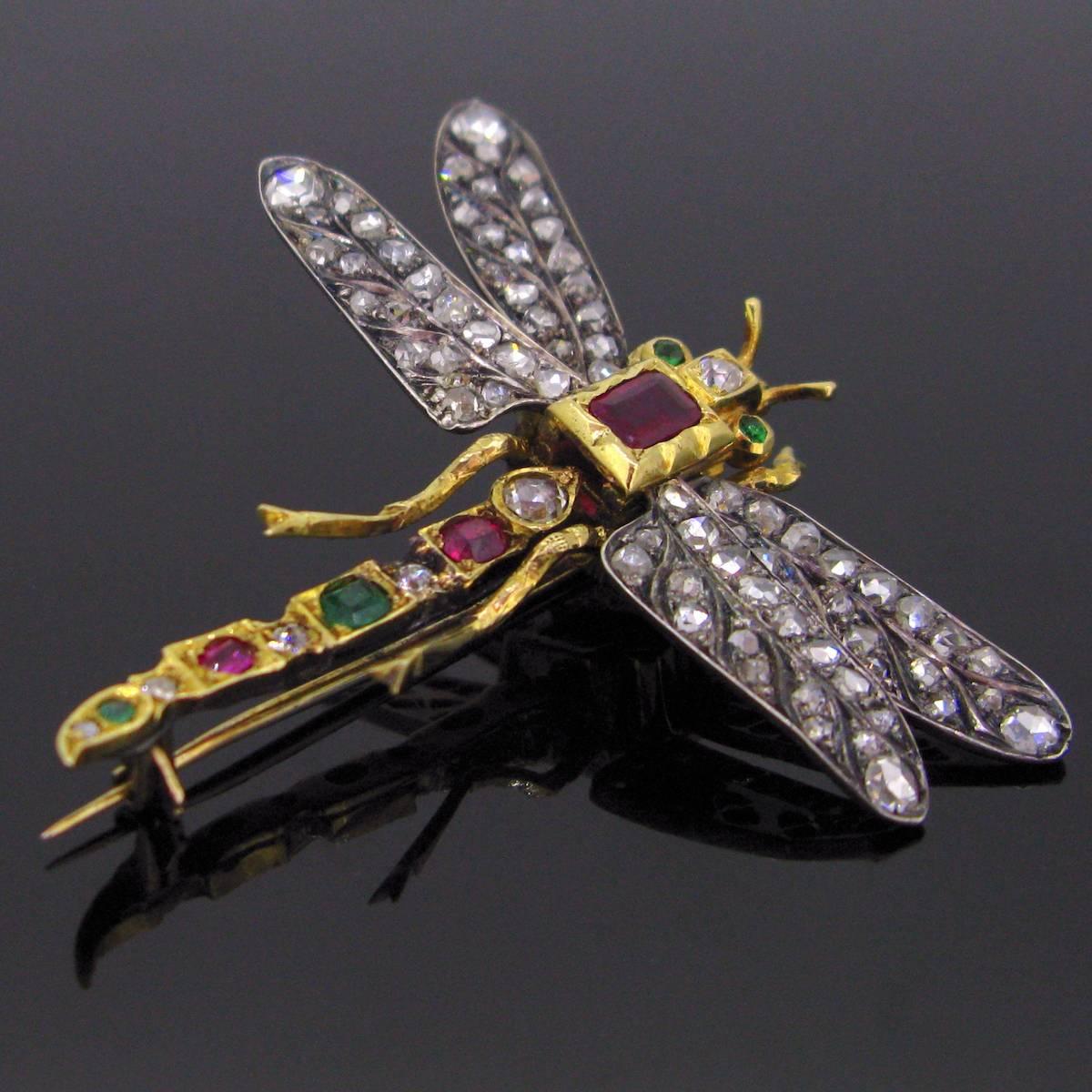 This brooch is made of 18kt gold and silver; there are 4 emeralds in total (two of them being the eyes), 3 rubies with the main one weighing approximately 0.40ct and the wings are set with rose cut diamonds weighing a total carat weight of 2.30ct.