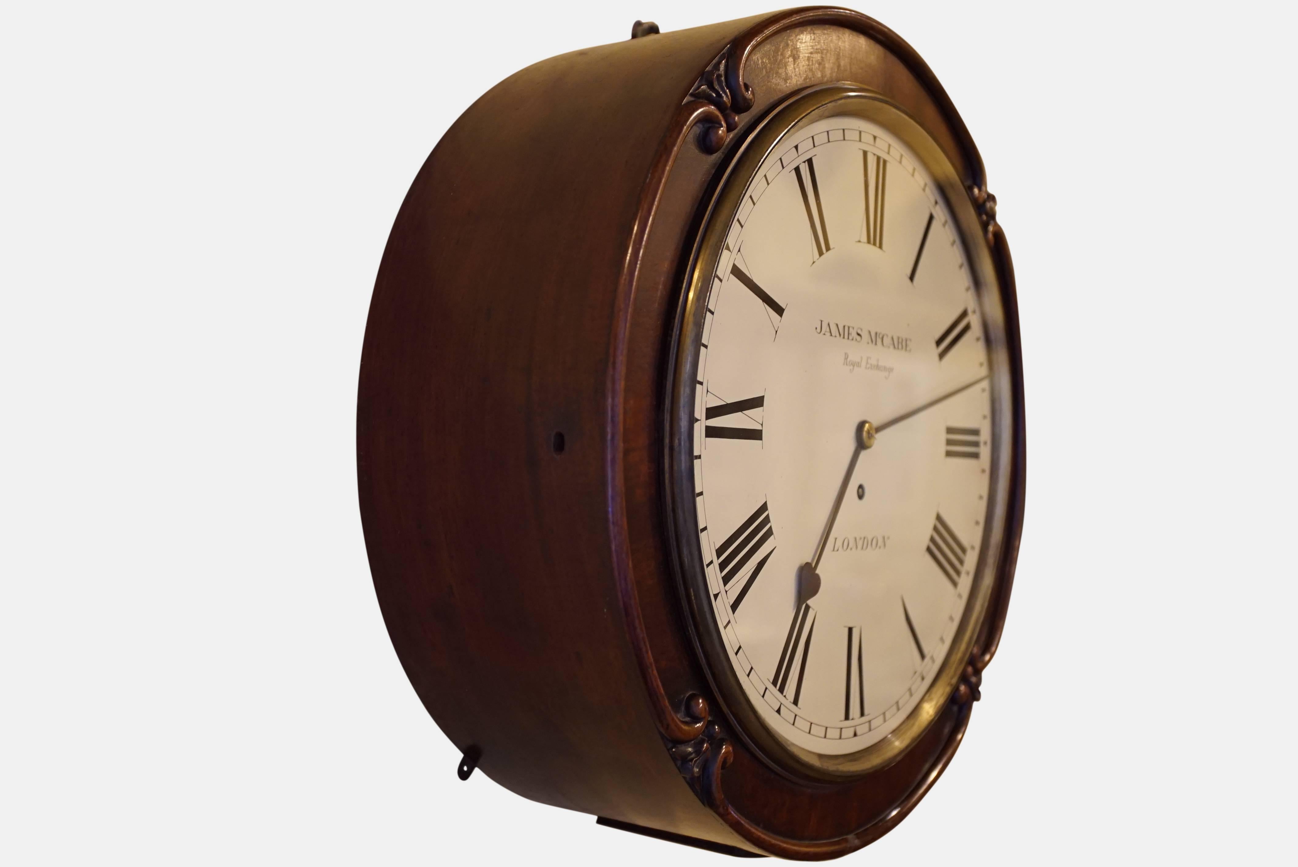 This clock is housed in a 17 inch mahogany drumhead case with a foliate carved design to the surrounding edge. It has two inspection hatches, one to the side and to the base both using the same key. A larger door is provided at the back of the clock