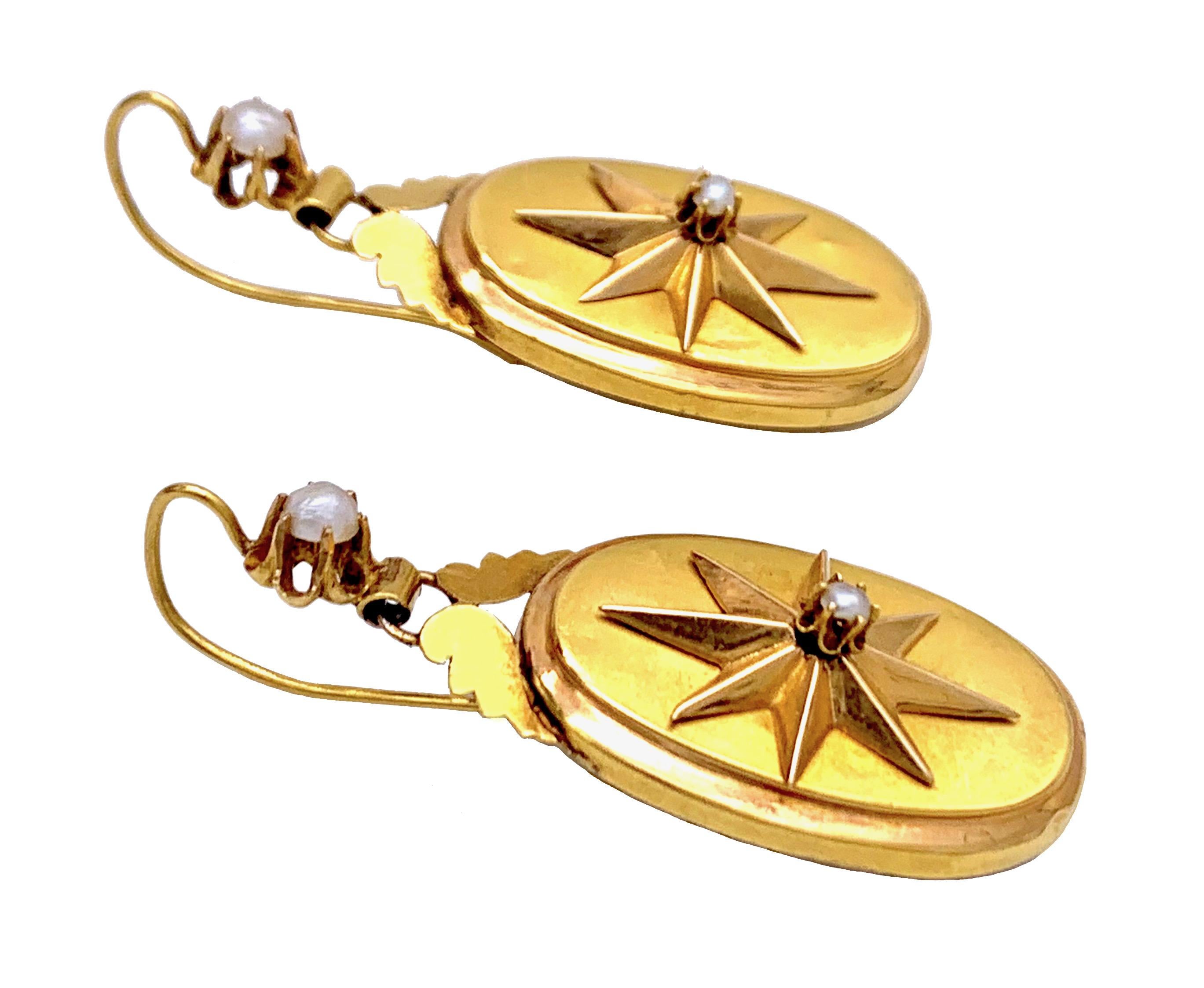 These star earrings were made out of 15 karat gold around 1865. Each earring is decorated with the relief of a star with a natural pearl in the center. The two larger claw set pearls embellish the top of the earrings.