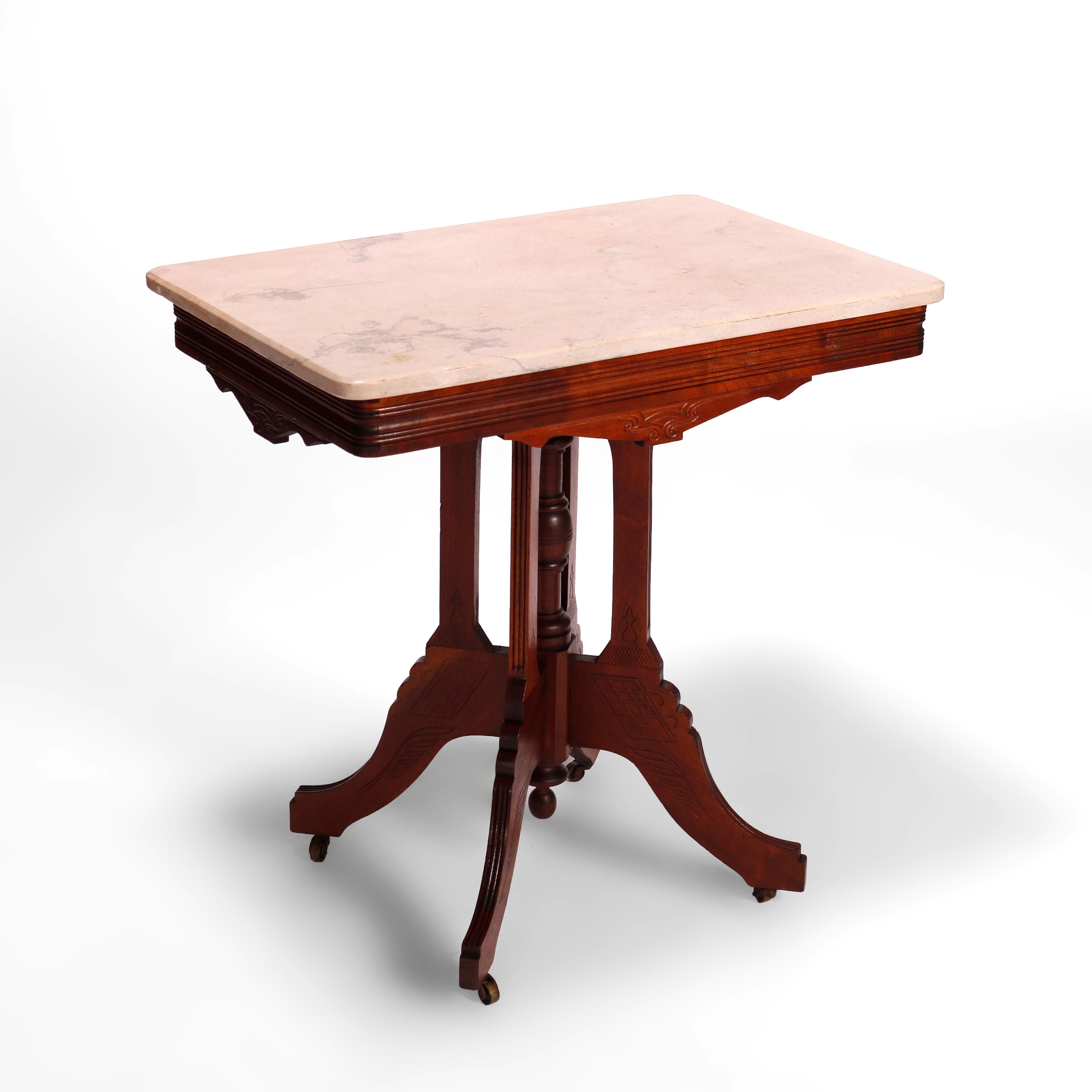 An antique Eastlake parlor table offers marble top over walnut base having shaped skirt, four supports with central turned column and raised on stylized cabriole legs, incised lattice and urn decorations throughout, c1890.

Measures- 30''H x 30''W x