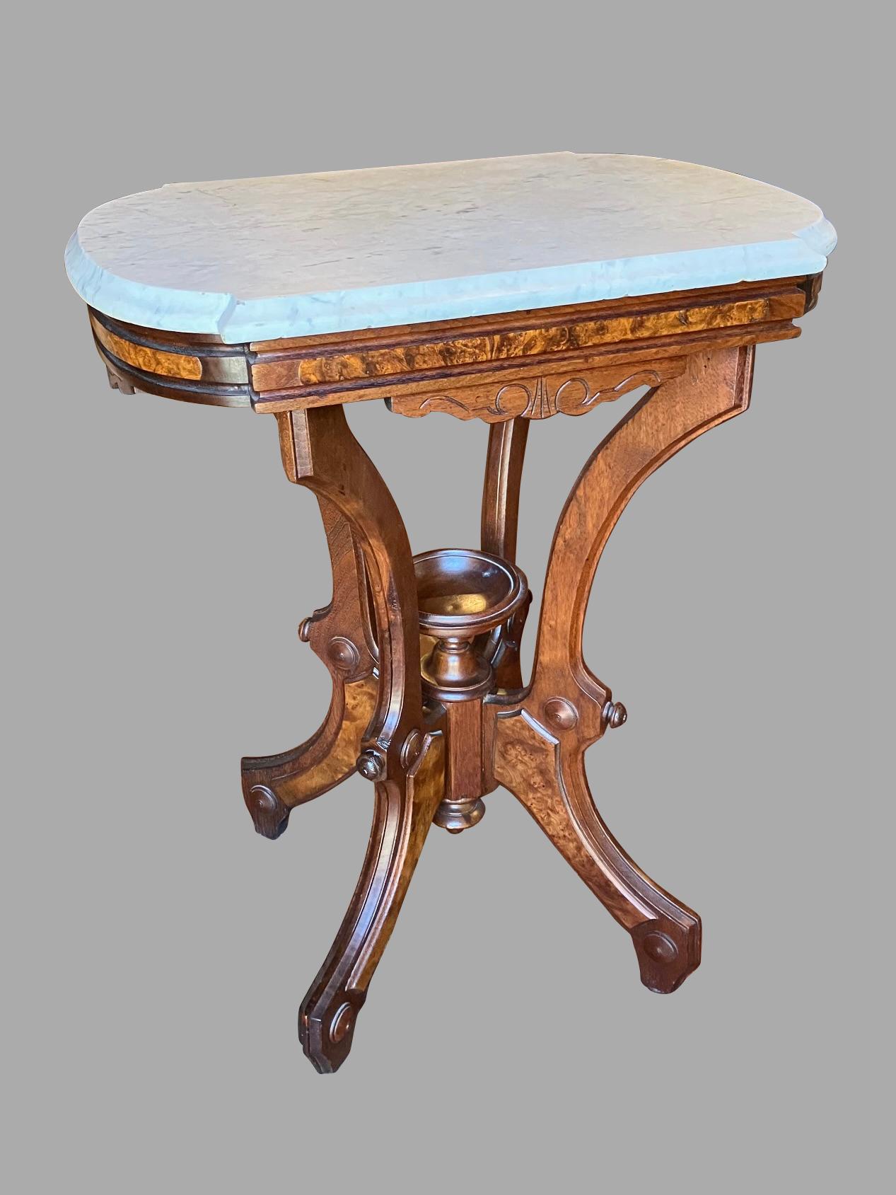An American walnut and burl walnut Eastlake style marble topped occasional table with a molded edge. The lower portion of the table is centered by a removable wooden urn. The burl walnut details on the piece add a touch of style and quality.