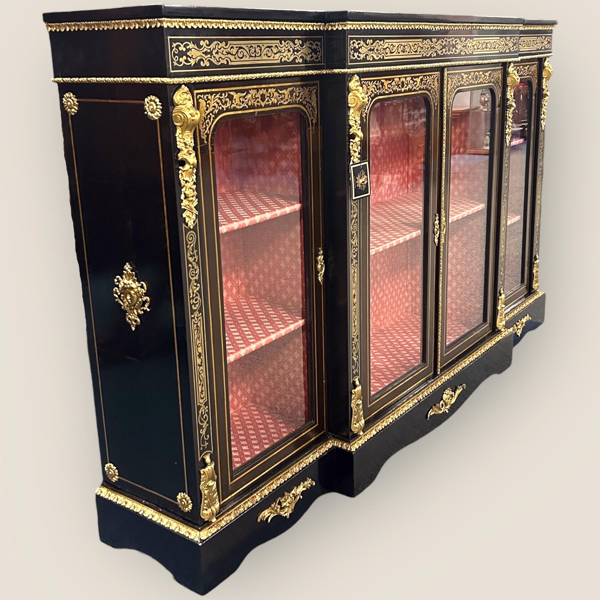 A Large Victorian Ebonised & Boulle Breakfront Credenza. A beautiful blend of boulle & brass ormolu decoration. With 4 glazed panelled and boulle inlaid doors, opening to reveal a patterned red interior.

Boulle
Boulle work (also known as buhl work)