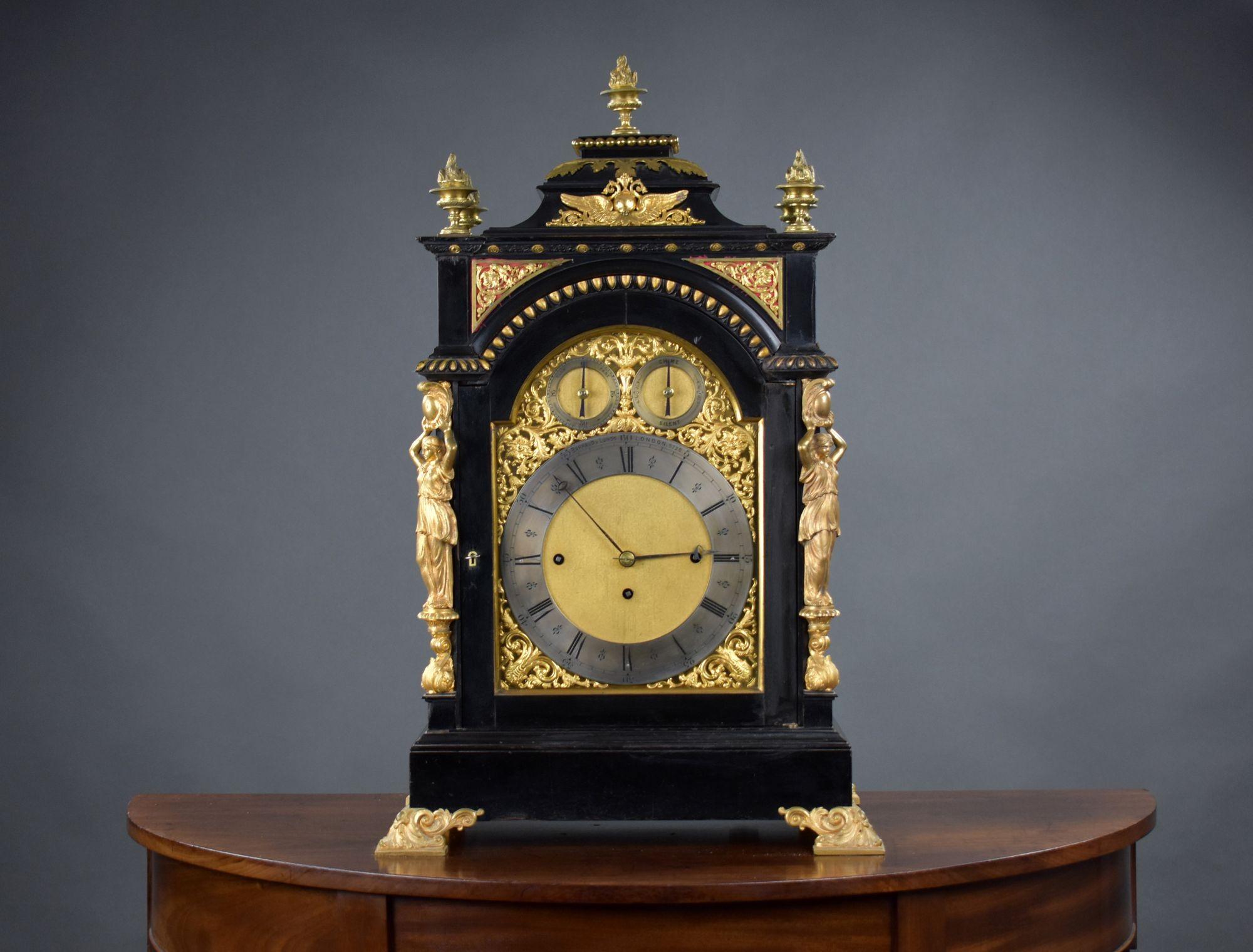 Il s'agit d'une horloge victorienne à support ébonisé de grande qualité, fabriquée par Barraud & Lunds, à Londres. La pendule est ornée de finitions et de montures en bronze doré d'origine, d'écoinçons dorés, d'un cadran argenté gravé avec chiffres
