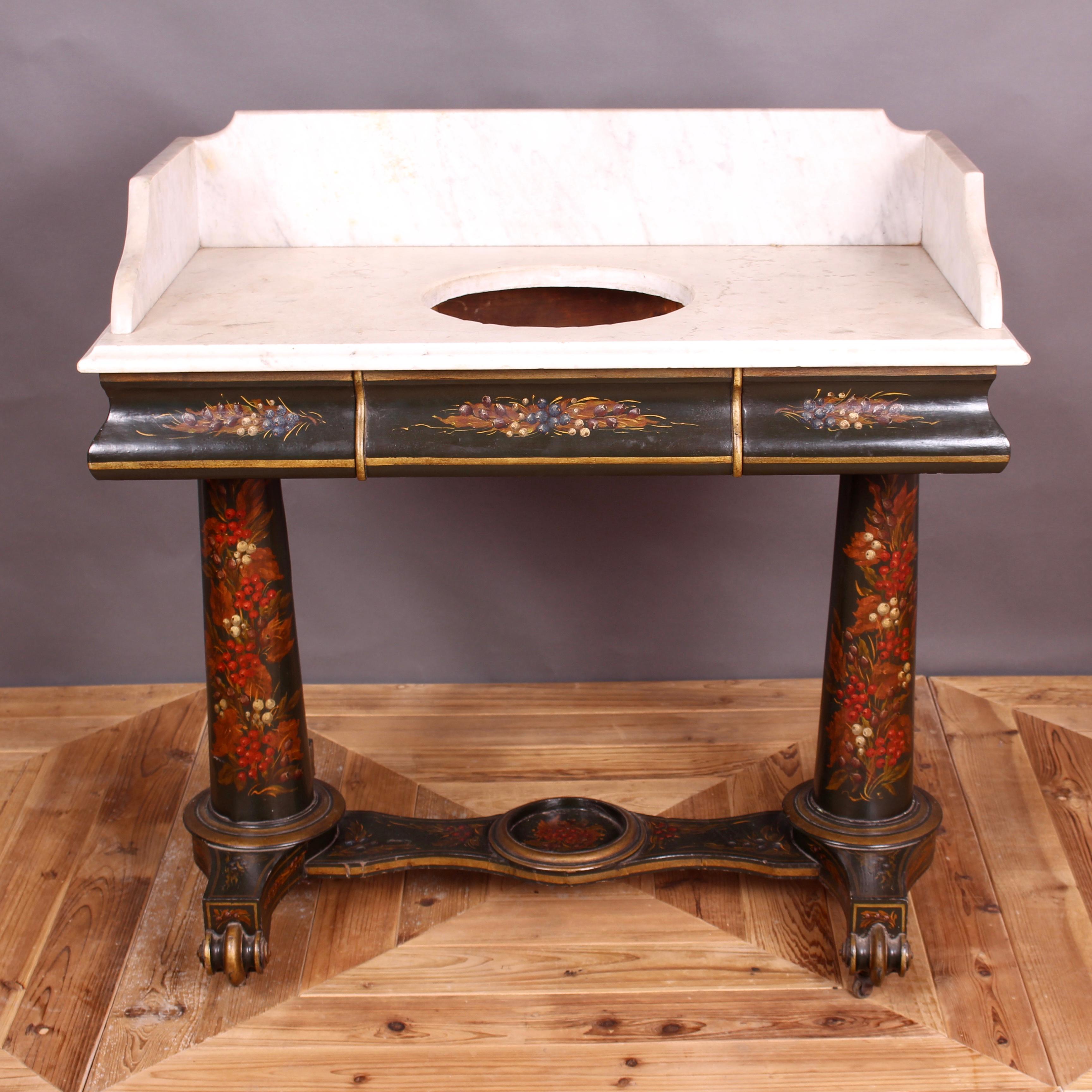 A delightful ebonized Victorian washstand. Having a marble top with pediment back and swept sides. The marble having a cutaway hole which would have once housed a wash bowl. The base having fitted drawers to either side and standing on large