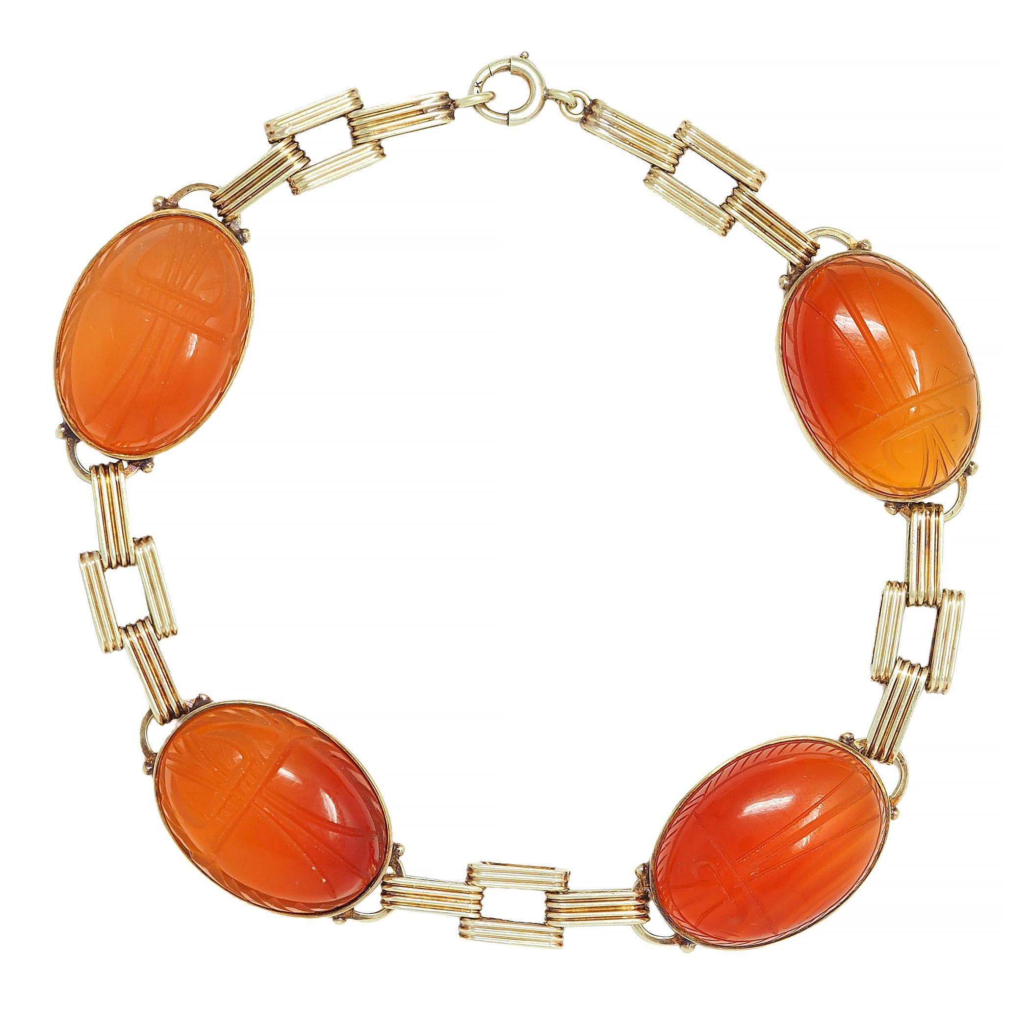 Comprised of fluted panther-style links alternating in pattern with carved carnelian links
Oval-shaped cabochons measure 12.0 x 18.0 mm - translucent medium reddish-orange 
Bezel set and carved to depict scarab beetles with hieroglyphs on