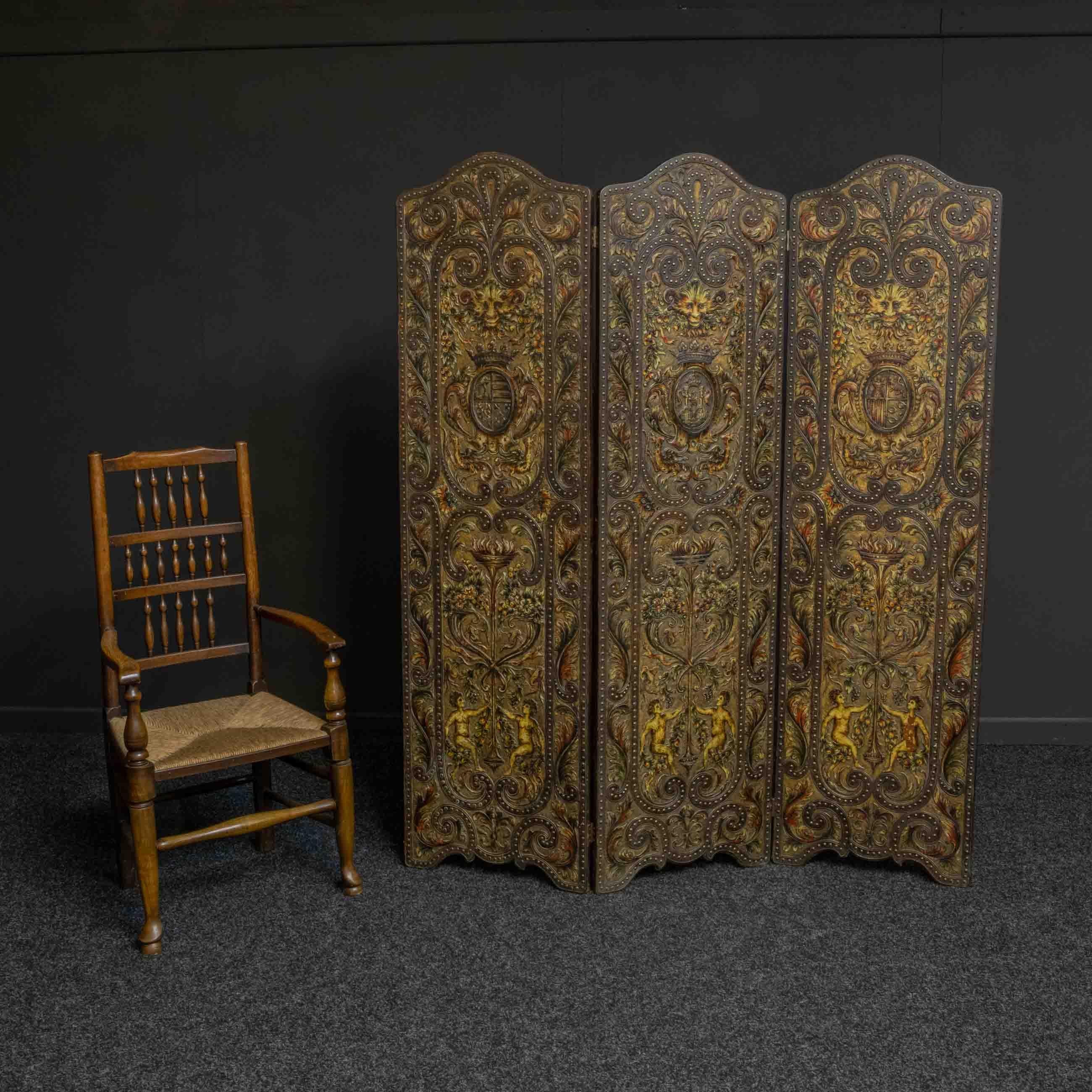 This is a very fine quality and heavy draught/dressing screen with highly detailed embossed leather on a hardwood frame. At the base are naked figures holding a flowering stem to a flamed torchere above which are mythological birds and grotesque