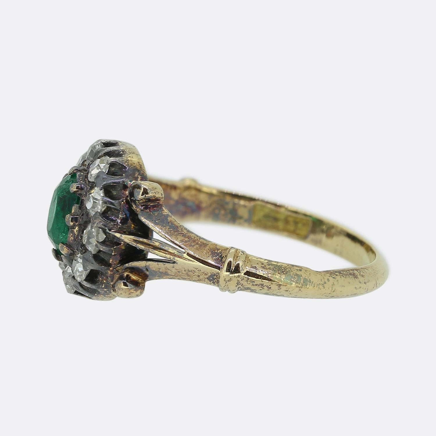 Here we have a charming cluster ring dating back to the Victorian period. This antique piece has been crafted from 18ct yellow gold and showcases an oval faceted natural emerald which sits slightly risen at the centre of the face. This principal