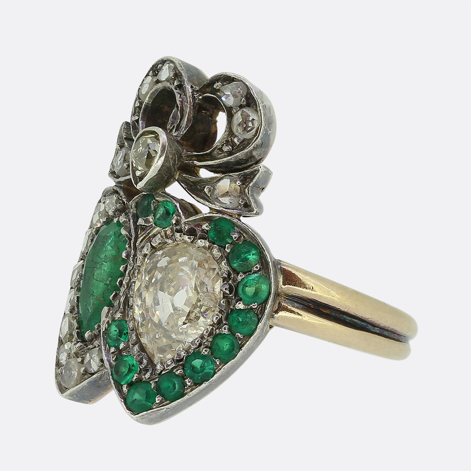 Hier haben wir einen entzückenden Doppelherzring aus der viktorianischen Ära. Dieses romantische antike Schmuckstück besticht durch die Kombination eines Smaragds im Birnenschliff und eines Diamanten, die beide in der Mitte gefasst sind. Diese
