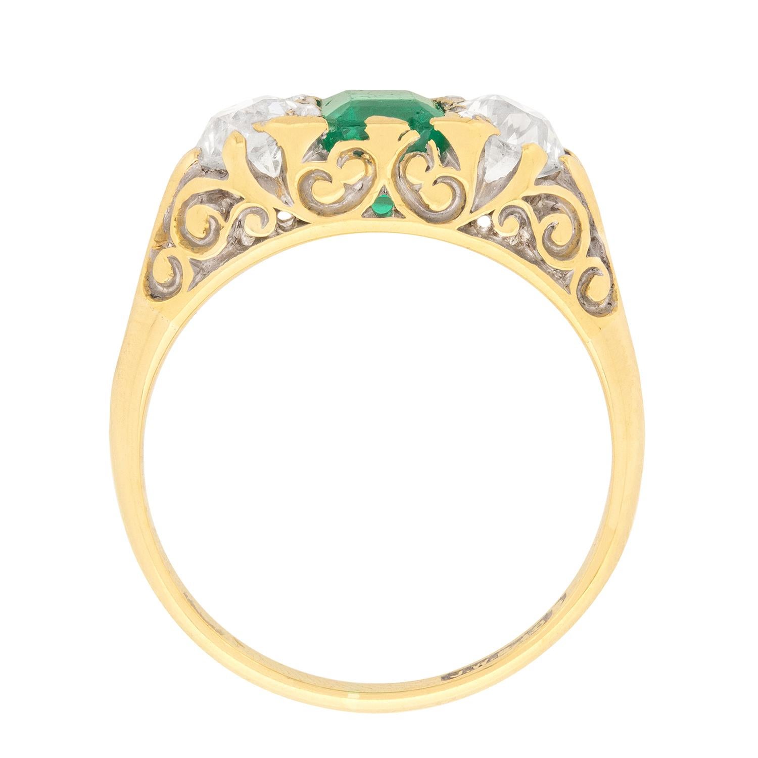 A vibrant 0.88 carat emerald is flanked by two 0.50 carat old cut diamonds in this Victorian ring. The emerald is certified to be natural and of Colombian origin by the Gem & Pearl Laboratory. The diamonds are G colour and VS2 clarity. The setting