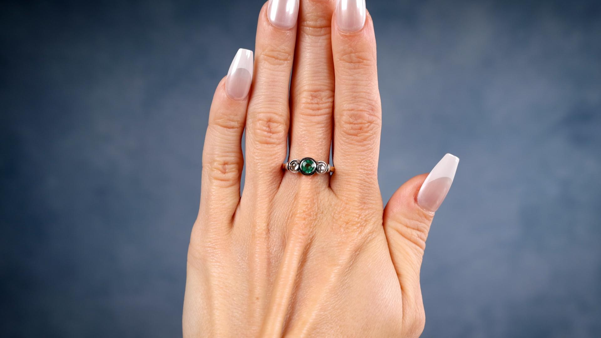 Ein viktorianischer Smaragd Diamant 14k Gelbgold Silber Drei Stein Ring. Mit einem runden Smaragd im Mischschliff mit einem Gewicht von etwa 0.40 Karat. Akzentuiert durch zwei Diamanten im alten europäischen Schliff mit einem Gesamtgewicht von ca.
