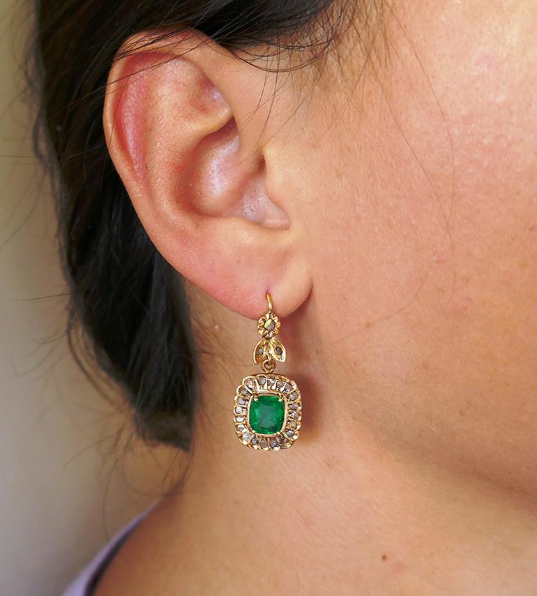 Lovely and wearable antique Victorian dangle earrings. 
The earrings are made of 18 karat (tested and stamped) yellow gold and set with natural cushion cut emeralds and old rose cut diamonds. The vivid green color of the emeralds keeps an eye