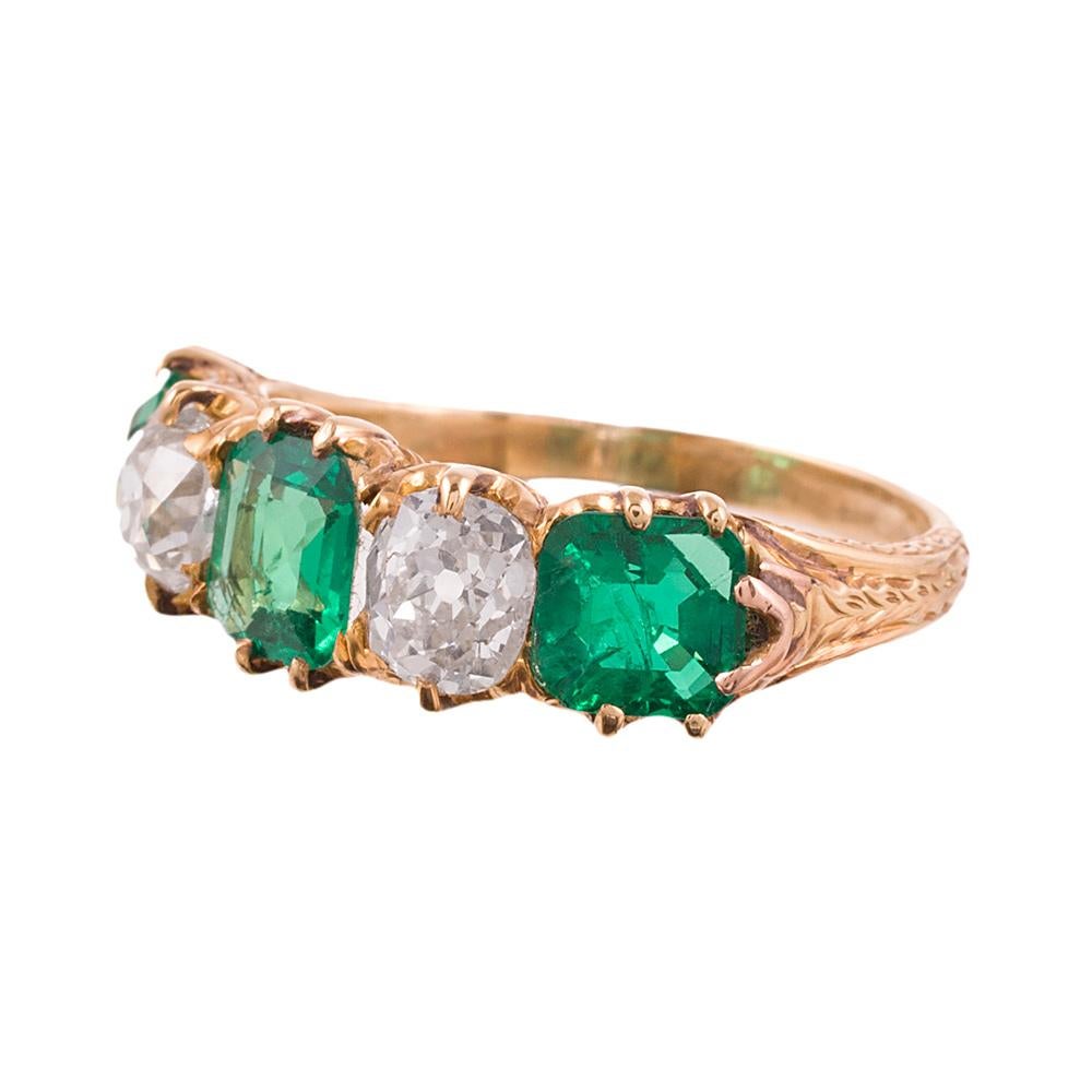 Made of 18 karat yellow gold, this ring builds on the classic three stone style and continues further around the finger, wearing like an eternity band from the top, yet with comfortable tapered sides. Three emeralds weigh approximately 2 carats in