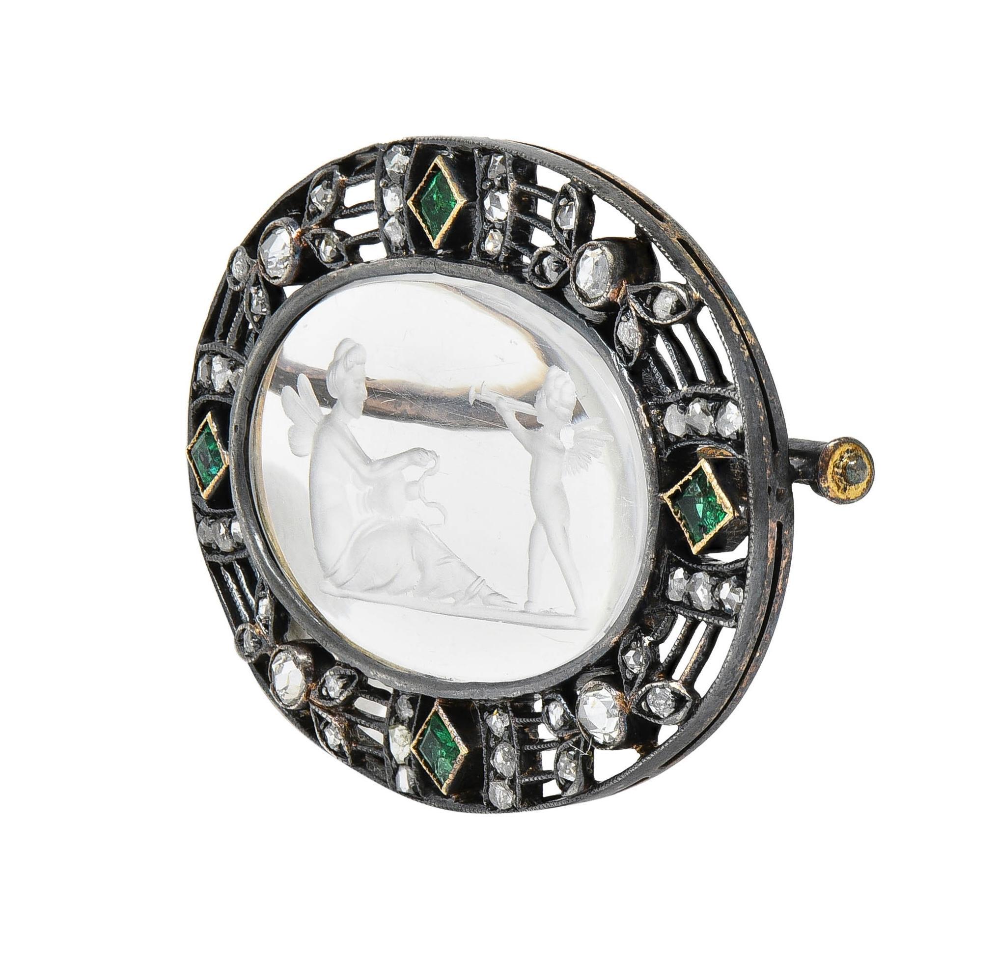 Centering an oval-shaped tablet of rock crystal quartz carved with an intaglio 
Transparent, glossy, and colorless - measuring 15.0 x 20.0 mm 
Depicting the Greek figures Cupid & Psyche with vase and trumpet
Bezel set with a pierced silver-topped