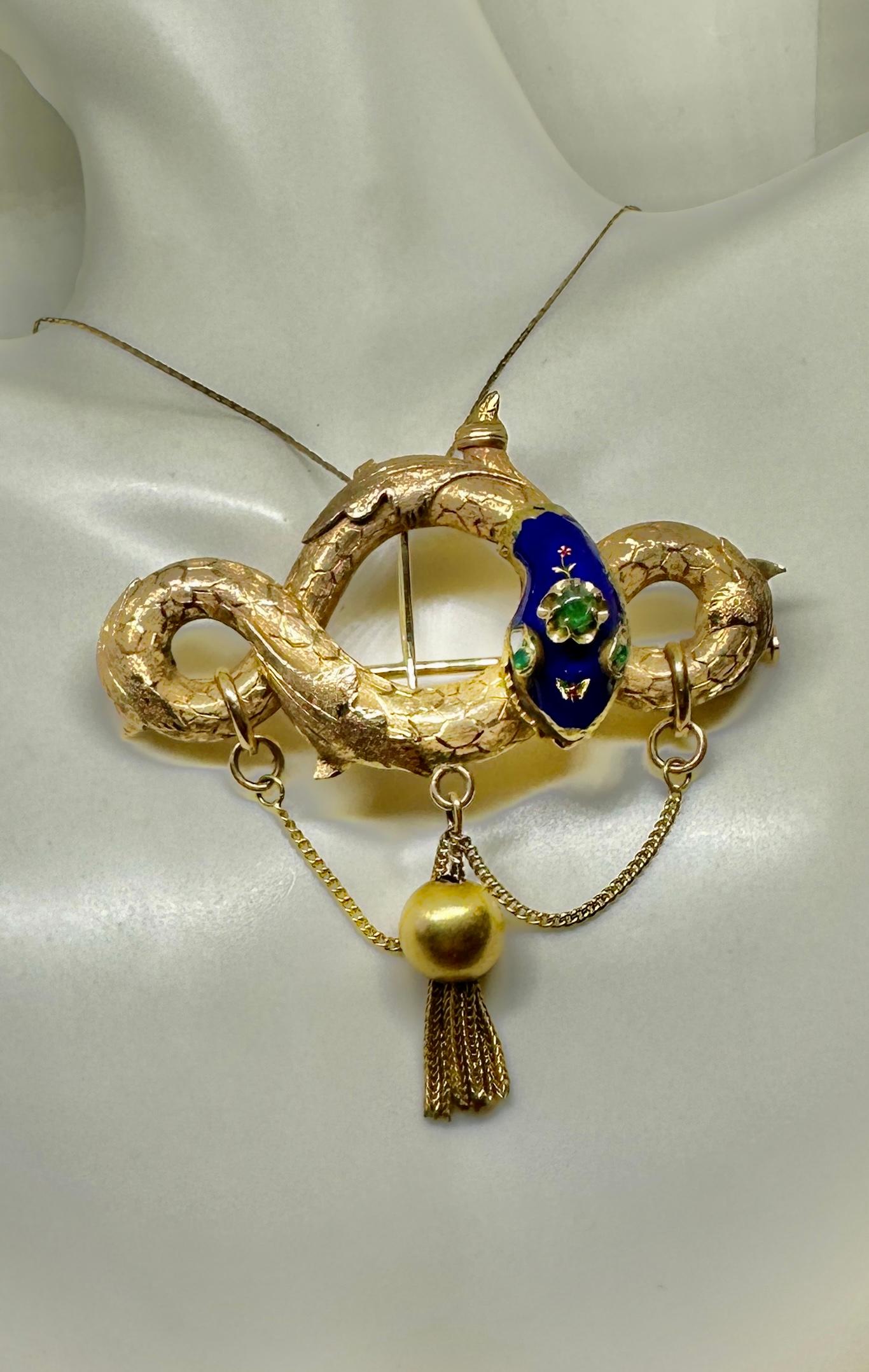 Si tratta di un antico ciondolo o spilla a forma di serpente vittoriano di qualità museale, ornato da gemme di smeraldo e smalto blu reale in oro 14 carati con un motivo a farfalla nello smalto.  Il ciondolo a forma di serpente risale al 1840 circa.