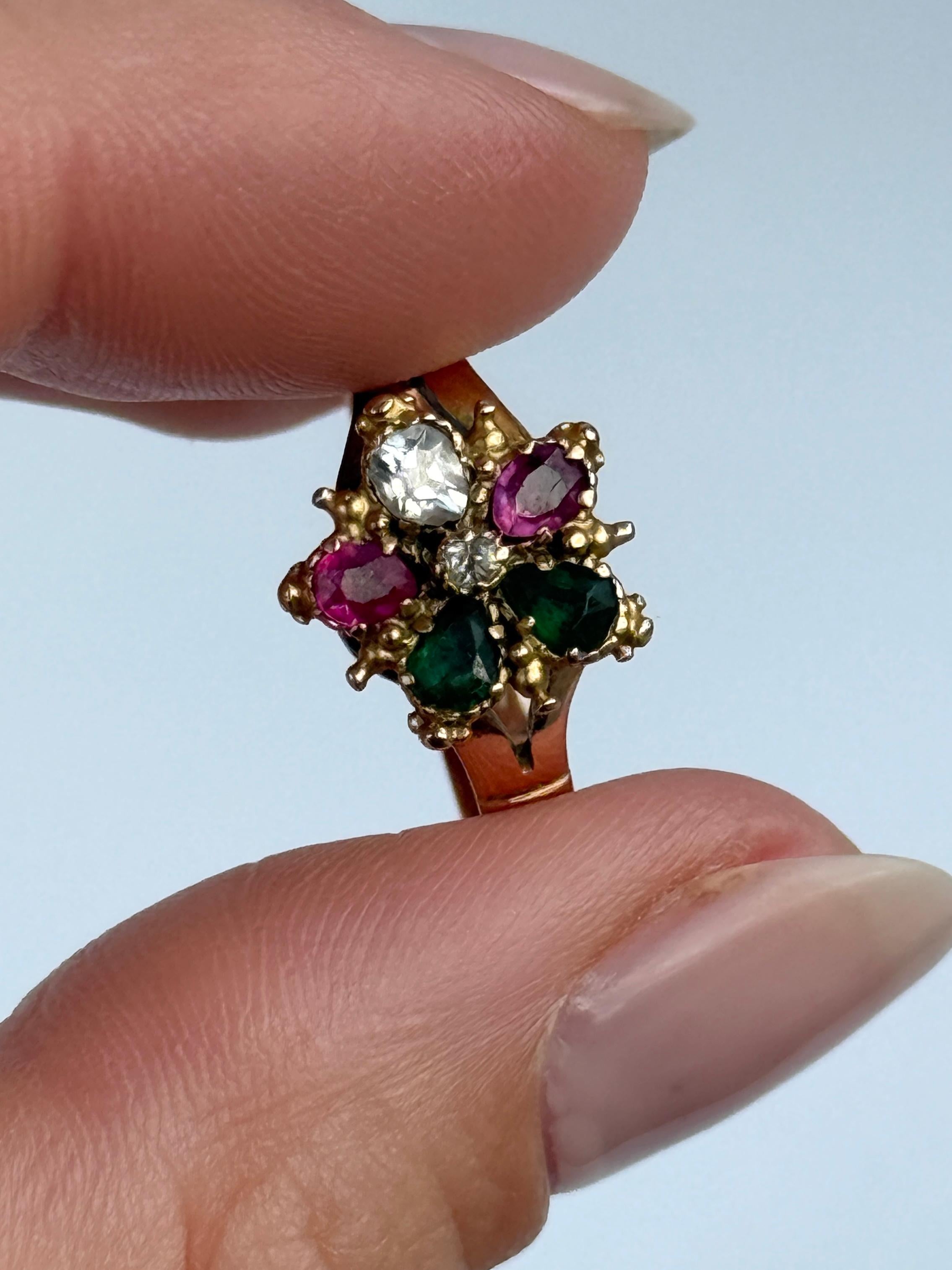 Questo splendido anello a margherita contiene due smeraldi, due rubini e un diamante. Al centro c'è anche un diamante incastonato. Modellato in oro 15 carati. 
Le pietre con taglio a pera misurano 10pt ciascuna e il diamante al centro misura