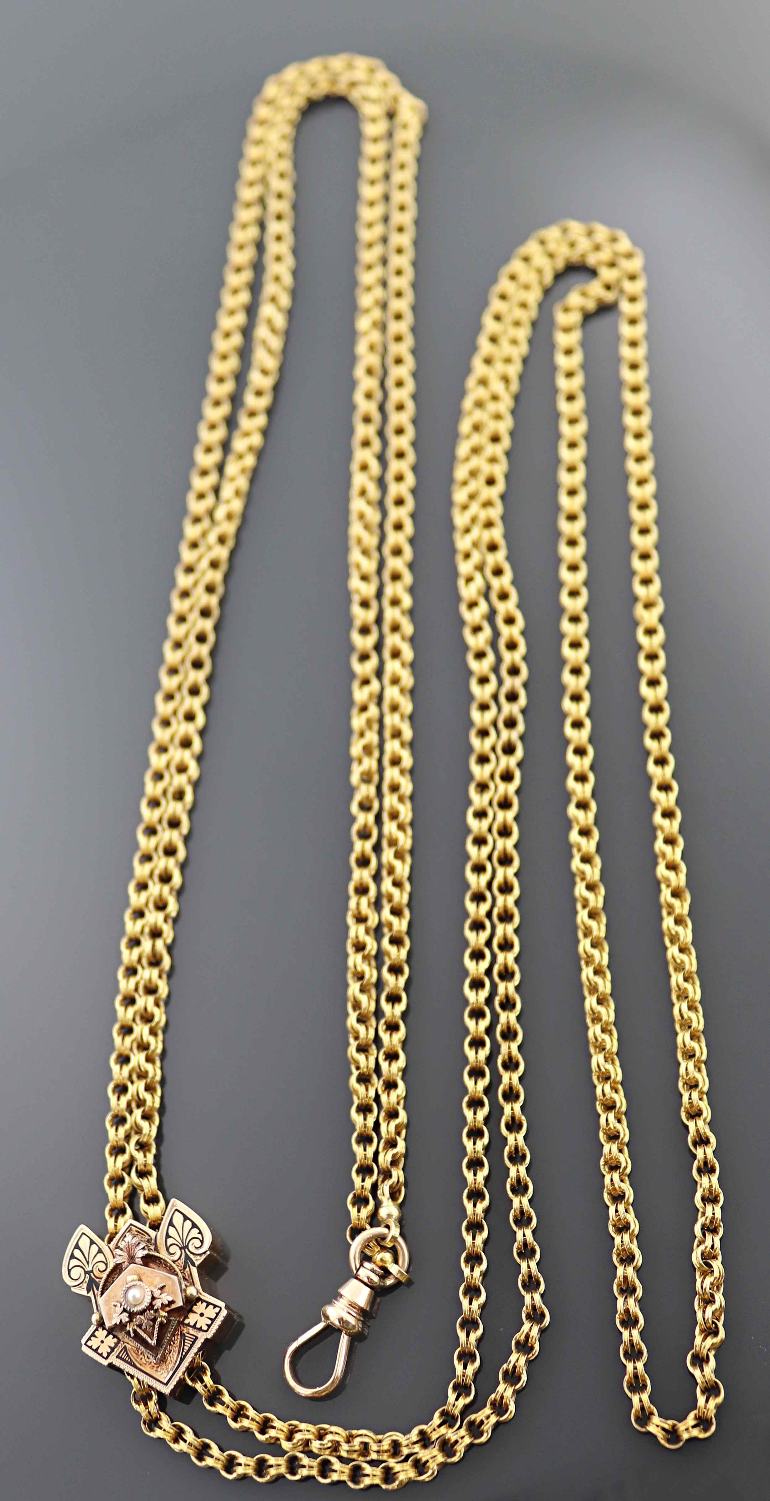 The 2.9 mm, 14k yellow gold, squared round double round link, features a 14k yellow gold slide, 21.6 X
18.2 12.2 mm, accented with a 2.00 mm, half seed pearl button and black enamel tracery, completed by
a swivel hook, forming a 32-inch necklace,