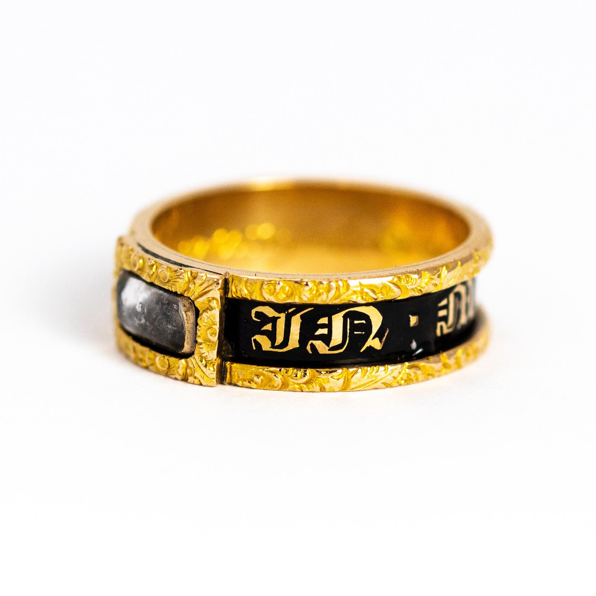 Sweet mourning band with black enamel and fine gold detail. This ring features a locket front holding a plait of hair behind a crystal panel. The inscription on the inner band reads 