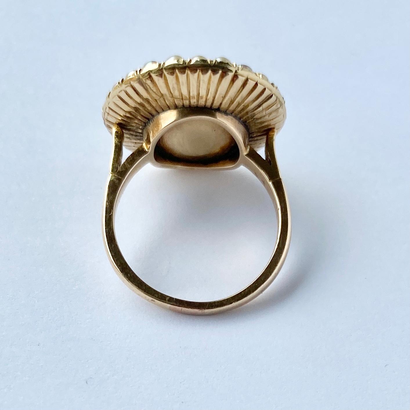 This bright blue enamel is complimented by the pale pearls and sparkling diamonds at the centre. The ring is modelled in 15ct gold. The diamond total is approx 20pts. 

Ring Size: N or 6 3/4 
Face Diameter: 20mm

Weight: 6.8g