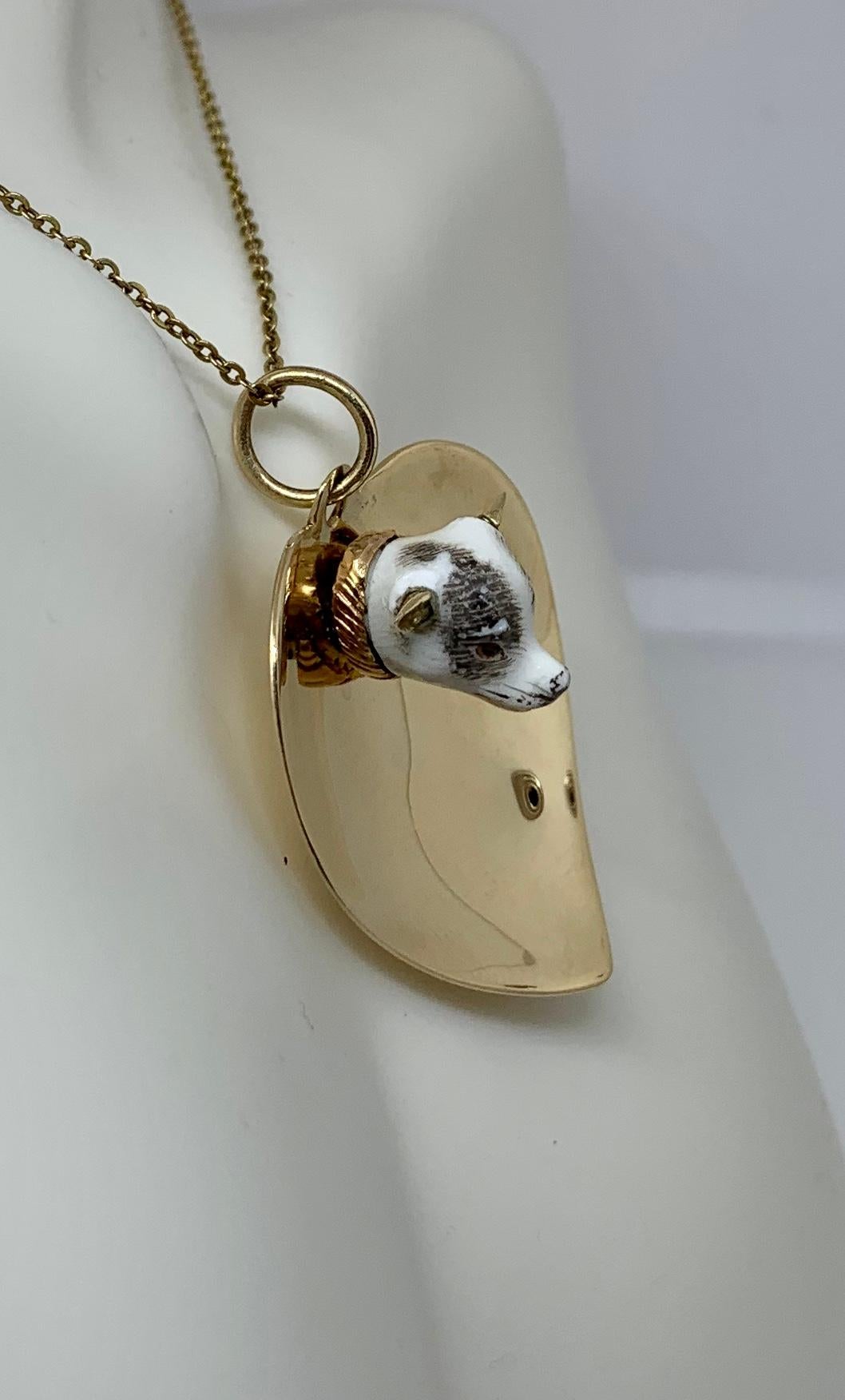 This is a gorgeous and very rare antique Victorian Enamel Dog Heart Pendant.  The extraordinary pendant has a fully modeled face of a dog set on a scalloped heart pendant in 14 Karat Gold.   The face of the dog is absolutely charming and it is so