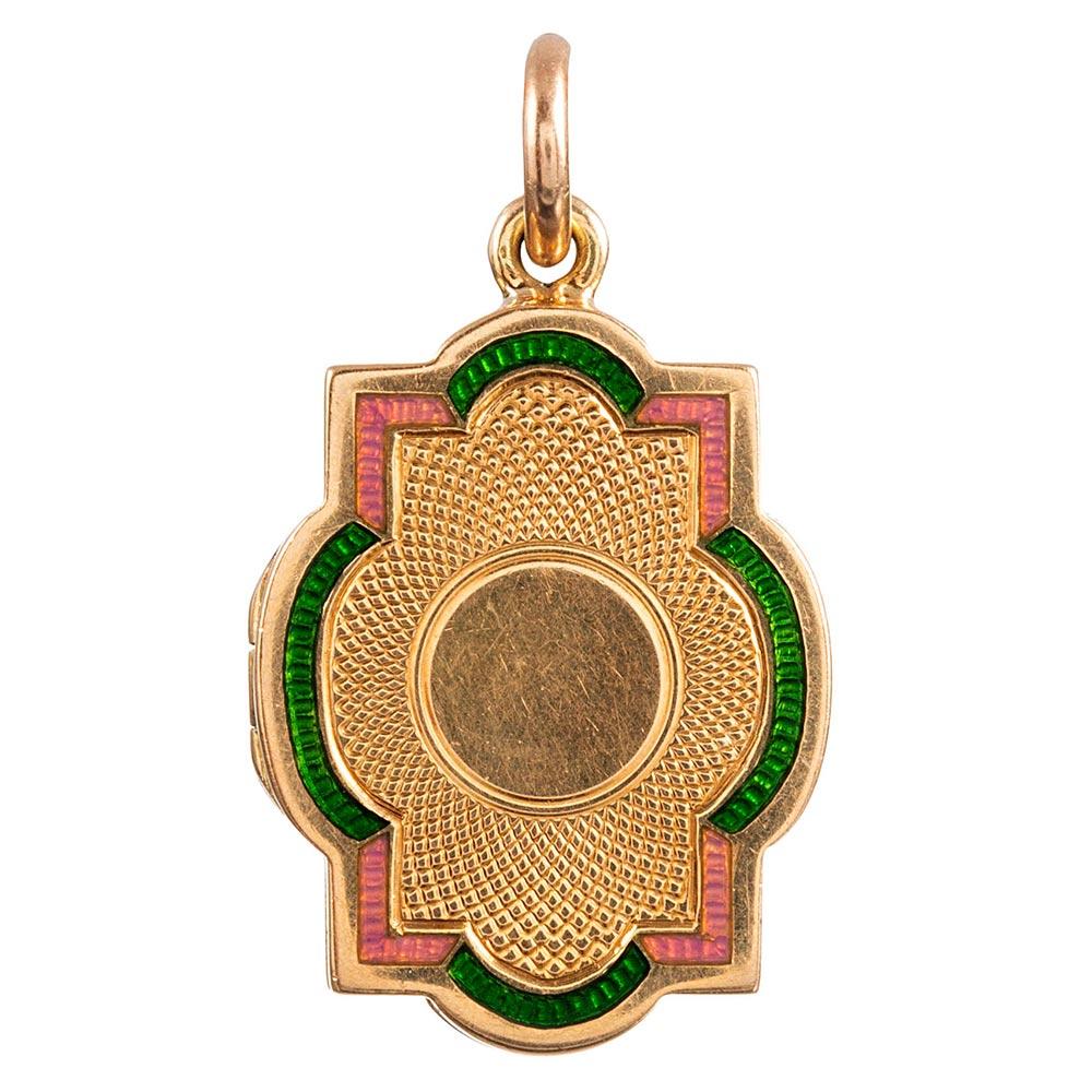 A bright and lovely color combination with grassy green and pink enamel framing the incredibly textured body of the locket, this sweet antique treasure remains nestled in its original presentation box. Made in the UK of 15 karat yellow gold, the
