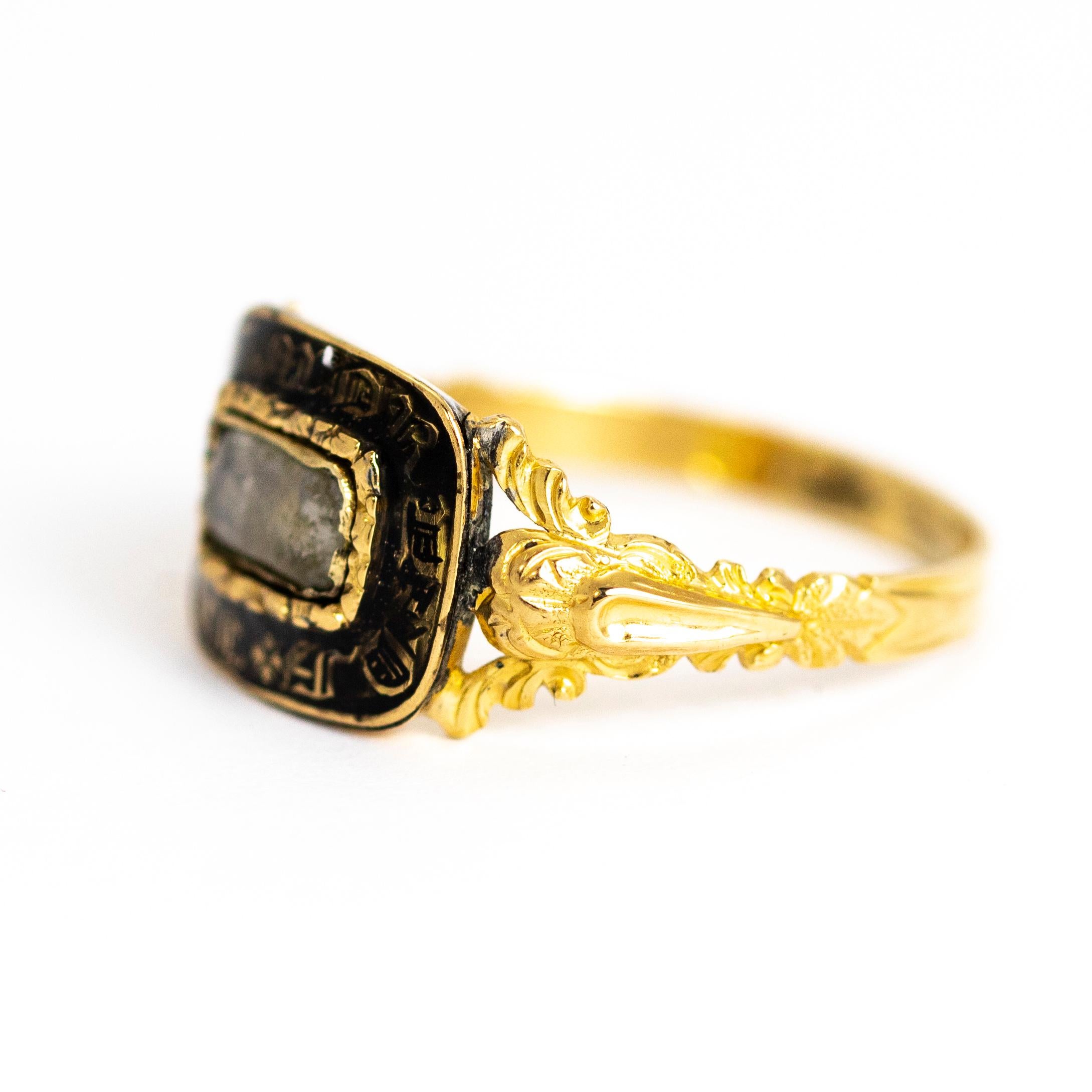 Beautiful mourning ring with highly decorative shoulders. This particular ring holds a lovely enamel face with the words 'In Memory Of' which surround a glazed panel. The inscription on the underside of the panel reads 