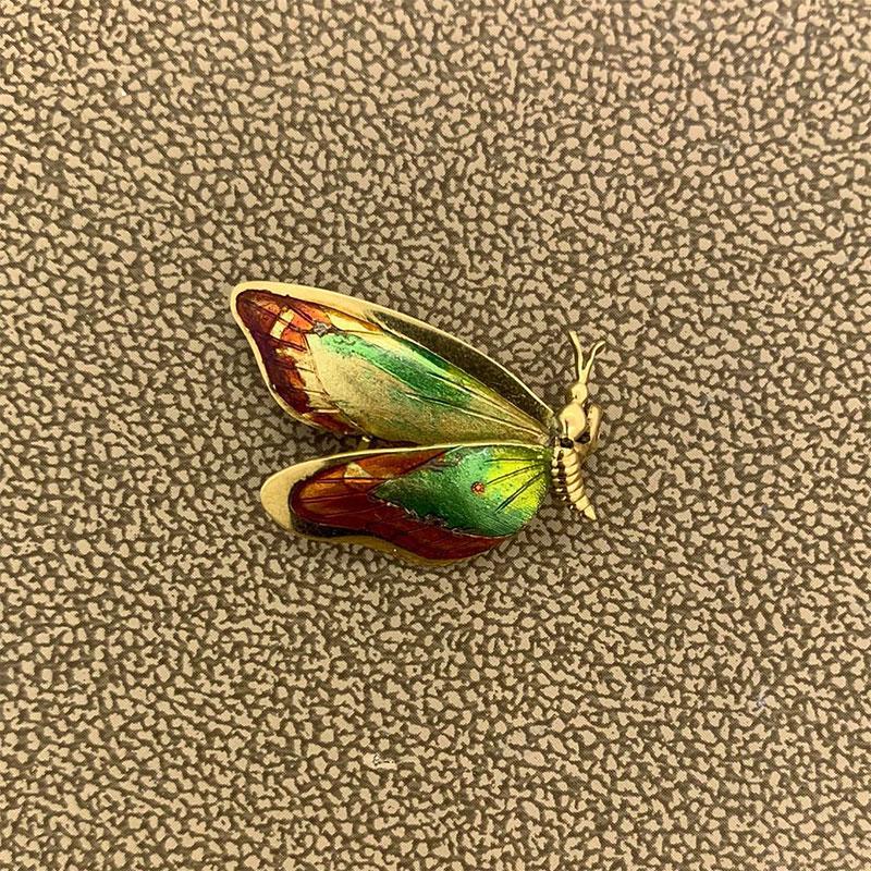A frolicking butterfly flapping its lively wings! The wings of this butterfly brooch are hand painted with energetic colors of enamel for this on the go fluttering beauty made of 14K yellow gold.   

Brooch Length: 0.95 inches

Brooch Width: 0.85