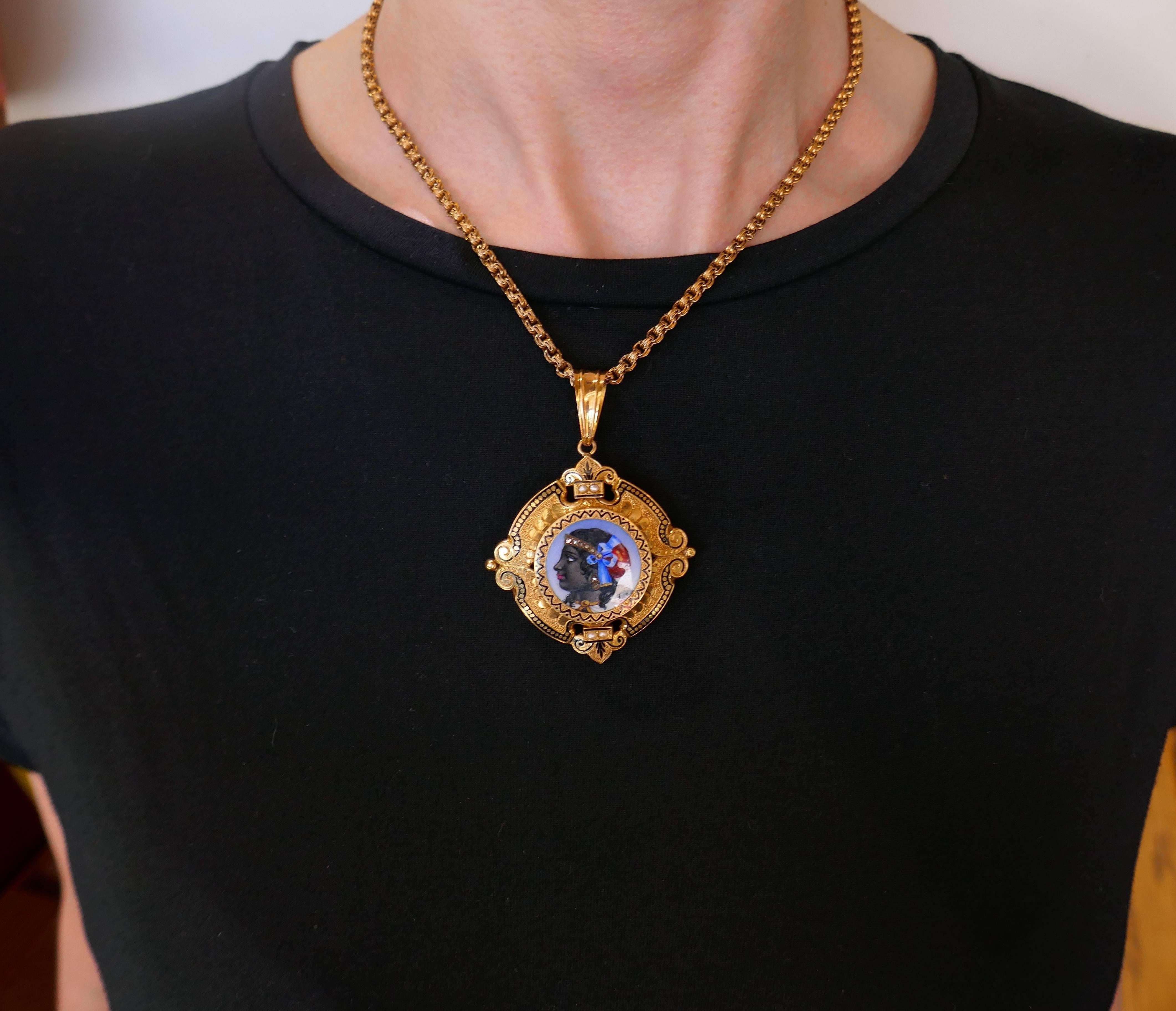 Amazing Victorian pin/necklace created in the 1900's. Features a handmade enamel painting depicting a woman's profile wearing a diamond diadem and earrings, and colorful head scarf. The painting is framed in yellow gold, accented with black enamel