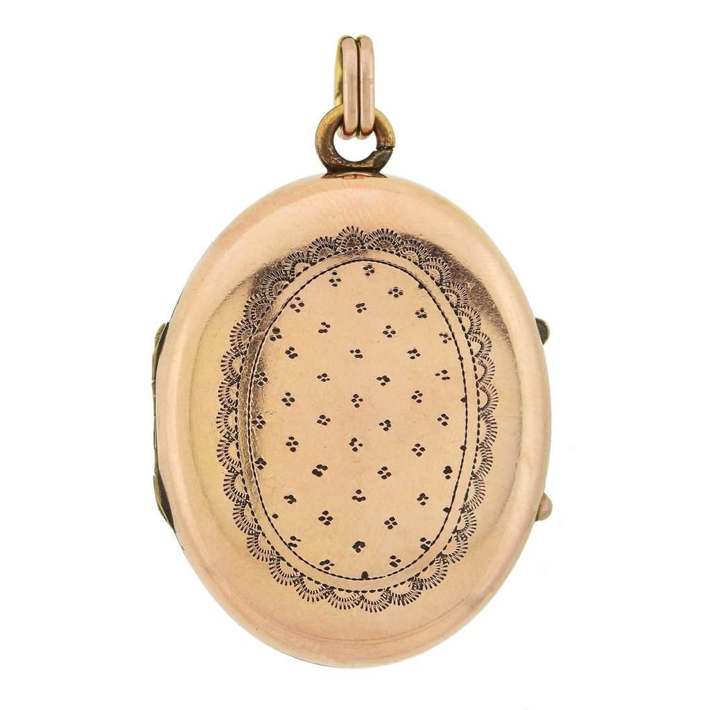 A gorgeous and unique locket from the Victorian (1880s) era! Crafted in 12kt yellow gold, this whimsical piece displays a hand-painted image of a purple-winged cherub behind locked bars, awaiting his release. The lovely image is painted on ceramic