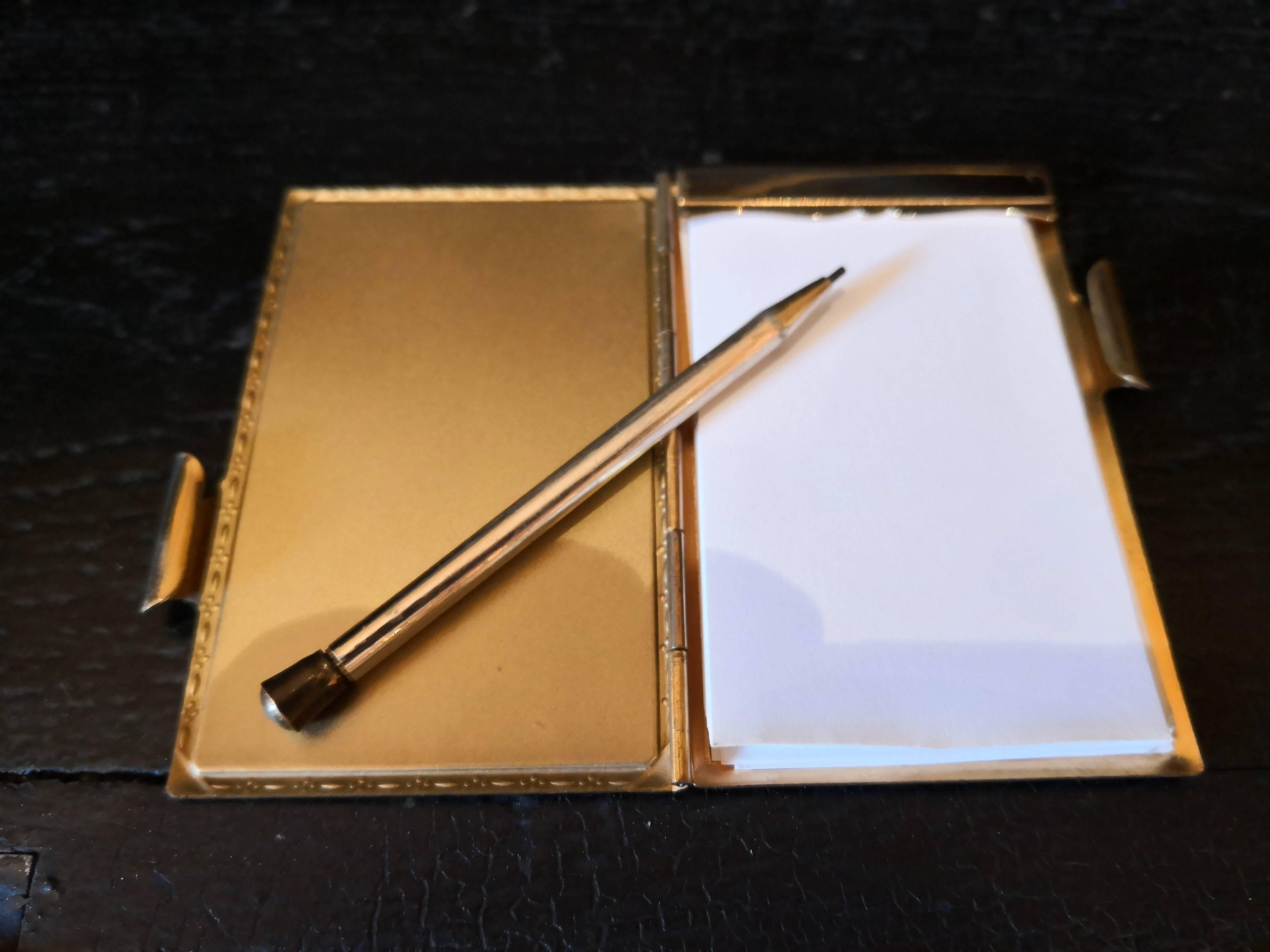 Charming tiny Victorian notebook with a small pencil in turqouise. 
Inside and backside gilded. Enameled cover shows a elegant man with a riding crop and a tophat in the style of Victorian. Inside little papers and on the side a small pencil.
