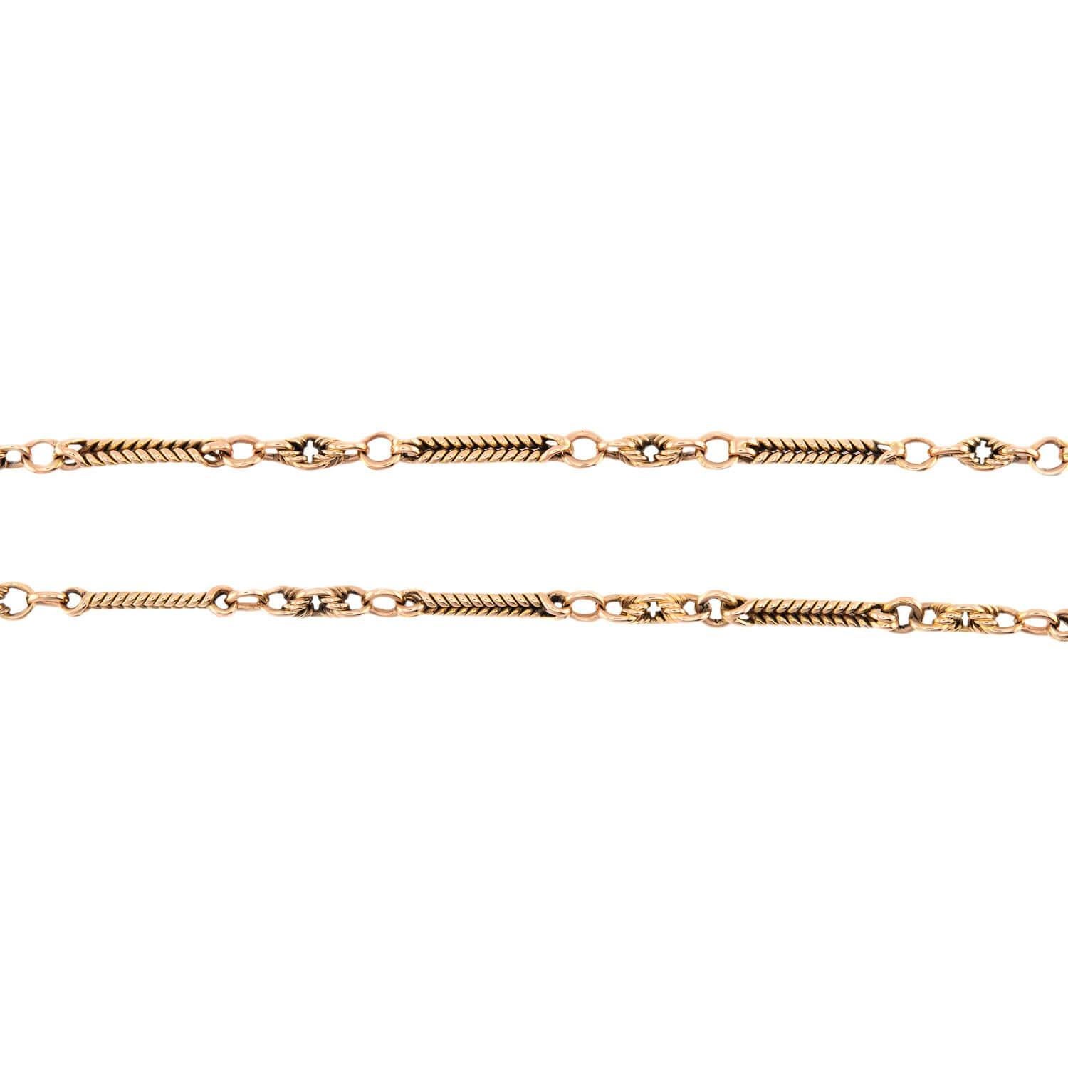 ¡Un fabuloso collar de cadena de reloj de la época victoriana (ca1890s)! Elaborado en oro amarillo de 15 quilates, este collar está compuesto por eslabones oblongos con un diseño entretejido. Los eslabones están unidos por anillas de salto lisas y