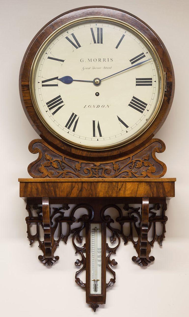 Victorian mahogany round dial clock resting on a foliate carved bracket with centrally mounted thermometer with bone engraved register plate.
 
Twelve inch painted dial with Roman numerals signed ‘G.Morris, Great Dover Street, London.
 
Eight