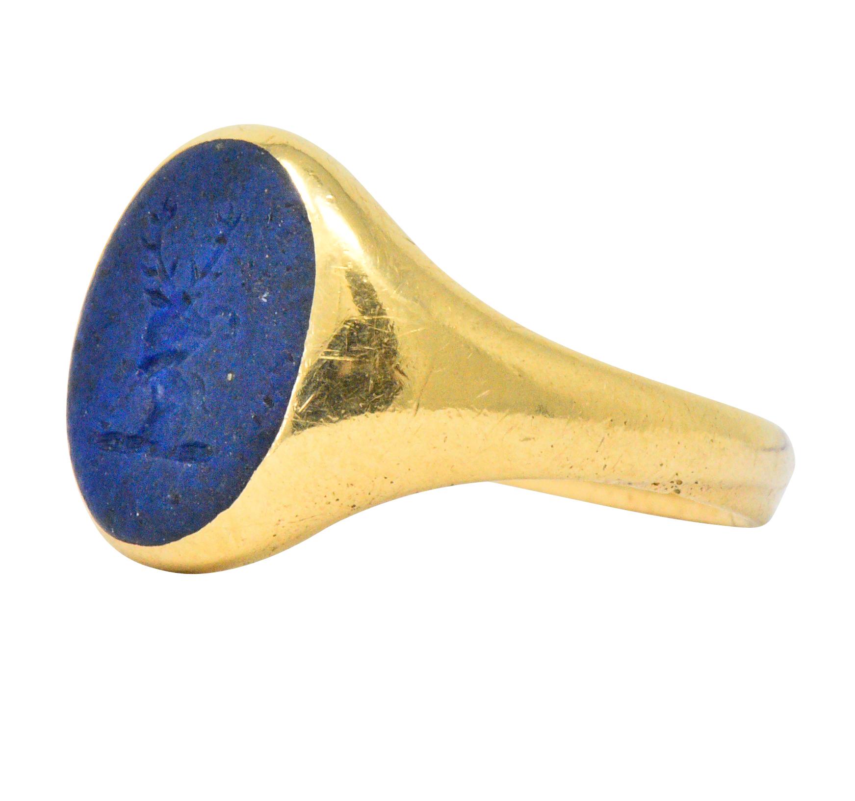 Centering an intaglio carved lapis lazuli depicting the head of a stag with a flower, rich navy blue with small flecks of pyrite

Deeply carved with an unpolished finish

Bezel set in rich gold

Stamped 18ct and tested as 18k gold

Ring Size: 8 &