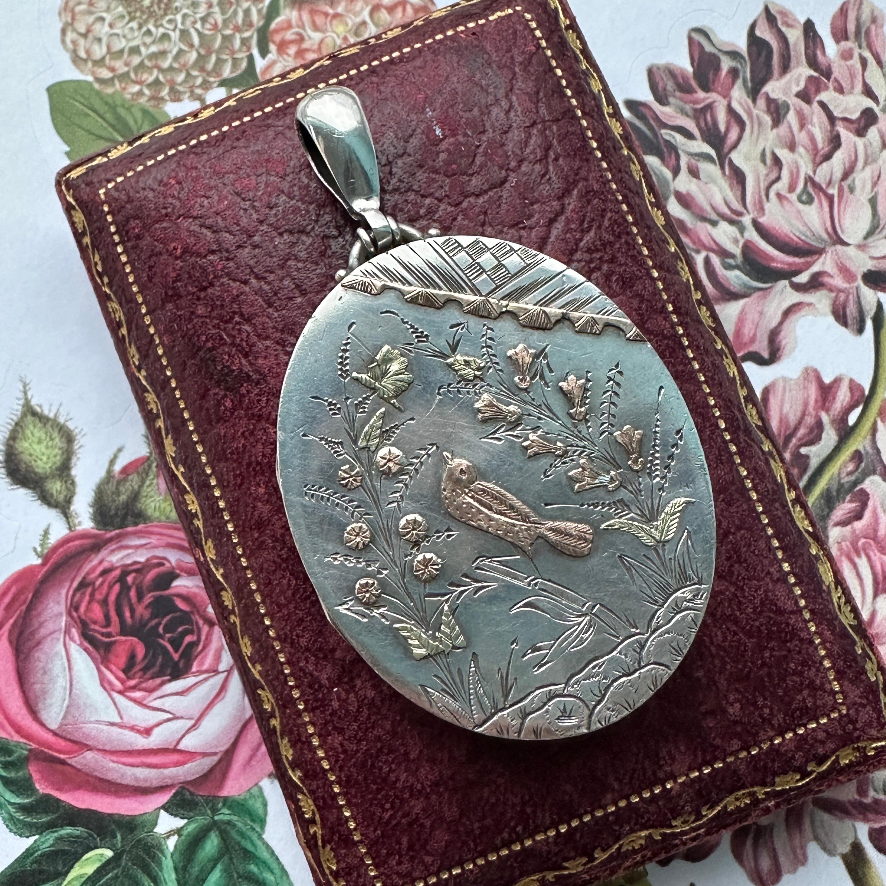 Locket ONLY. Does NOT include chain. 

Details:
Victorian European Aesthetic Movement silver locket, dating between 1860-1880's. Sweet, romantic Victorian bird themed silver, yellow and rose gold locket pendant. There are sweet flowers, reeds, and a