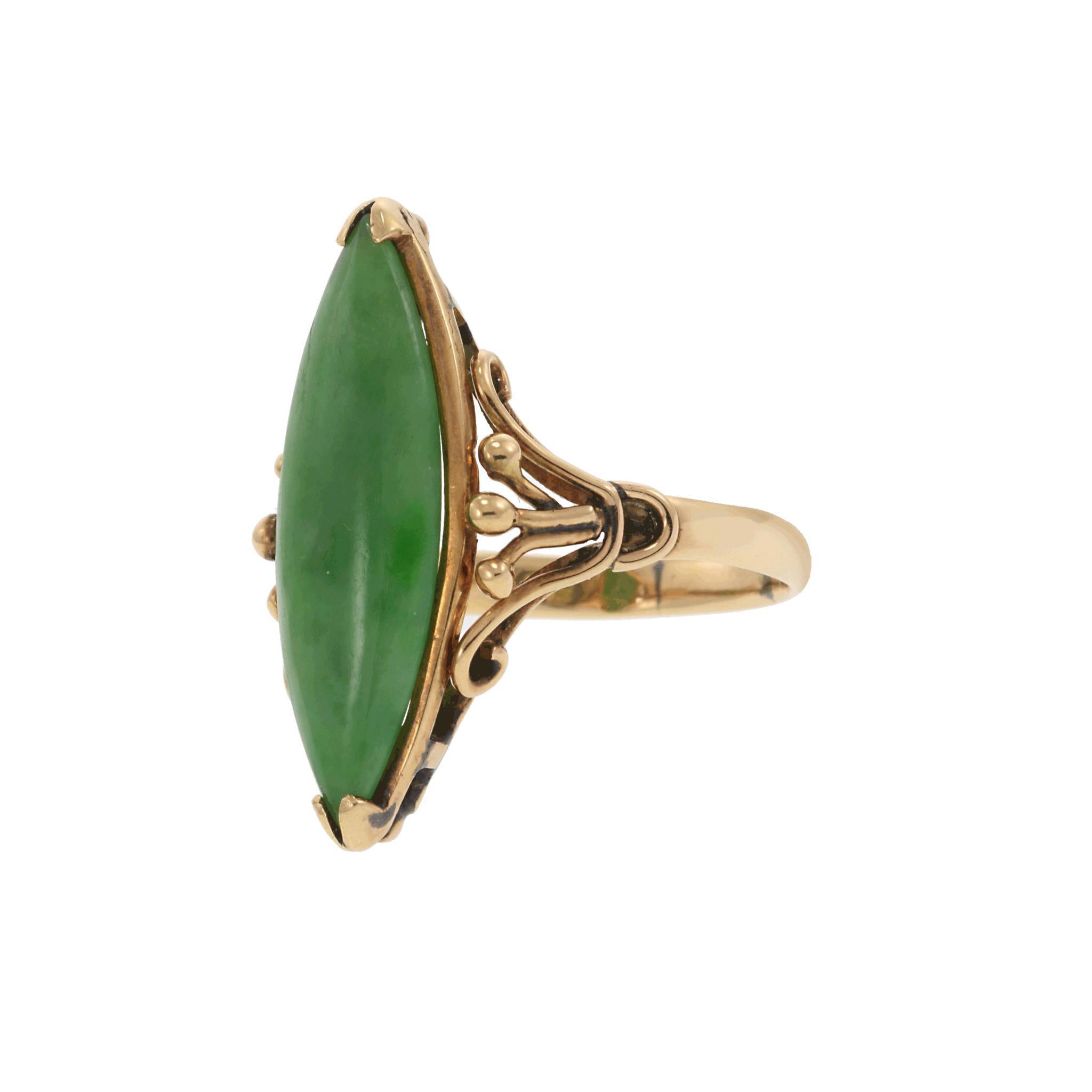 Step into the elegance of the Victorian era with this exquisite 14K gold statement ring, a true testament to 19th-century craftsmanship. The design features a striking marquise-cut jade stone in a vibrant green hue, symbolizing prosperity and
