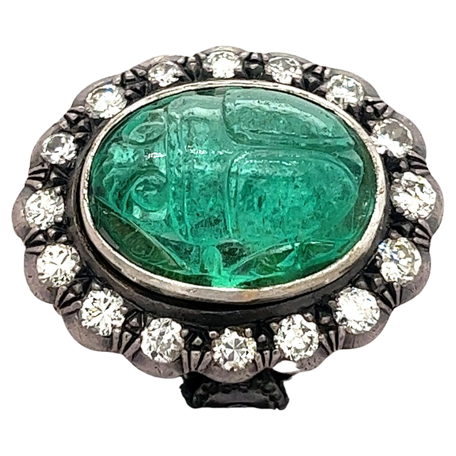 Antiguo halo victoriano de esmeralda tallada de 15 quilates y diamante de talla redonda en oro de 18 quilates y plata. La esmeralda está tallada a mano en un intrincado motivo de escarabajo, engastada en bisel con un vástago de anillo abierto por
