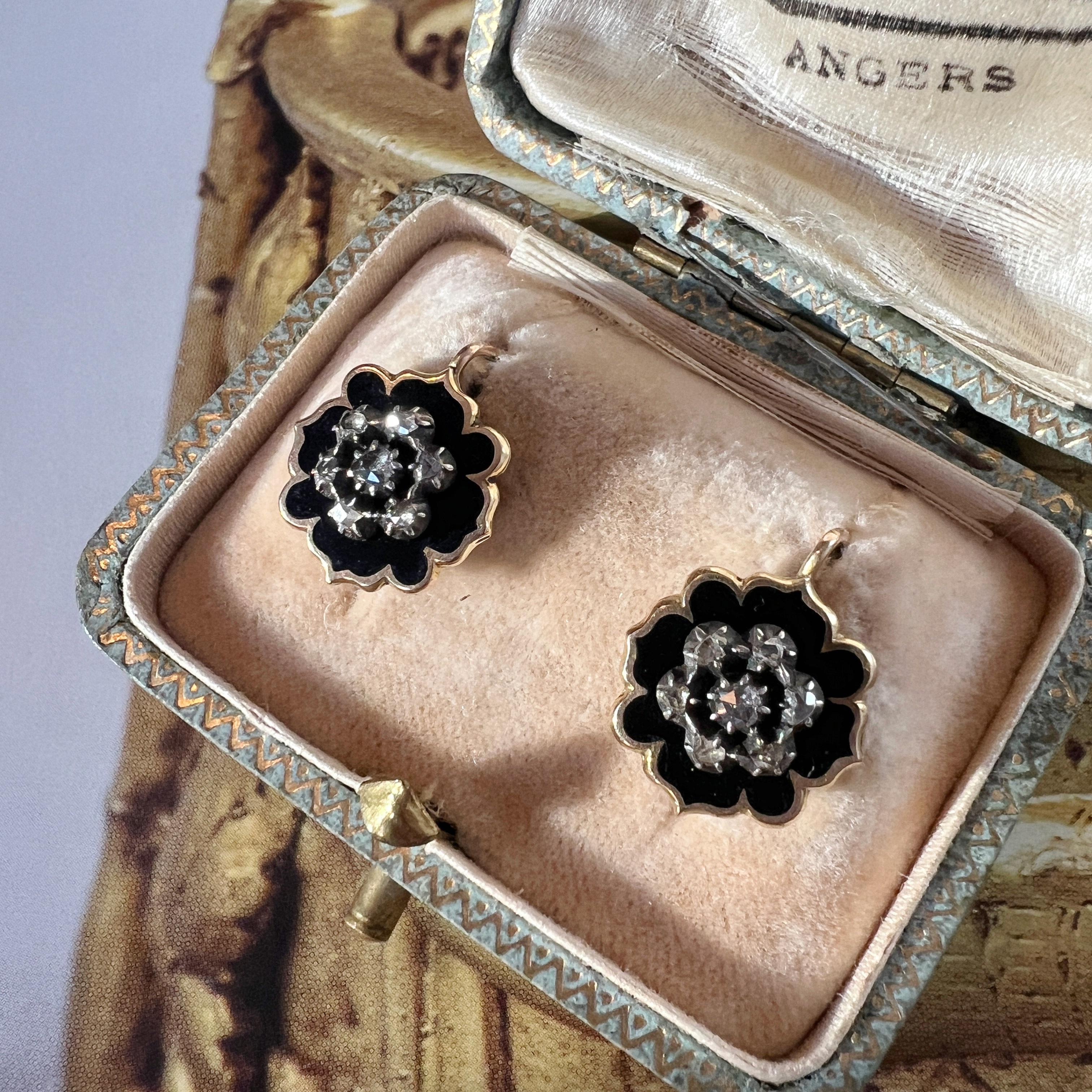 For sale a beautiful pair of 19th-century, Victorian-era earrings, a true embodiment of timeless elegance.

Crafted in 18k gold, these dangle earrings feature a black enamel lotus flower panel, adorned with seven dazzling rose-cut diamonds on each
