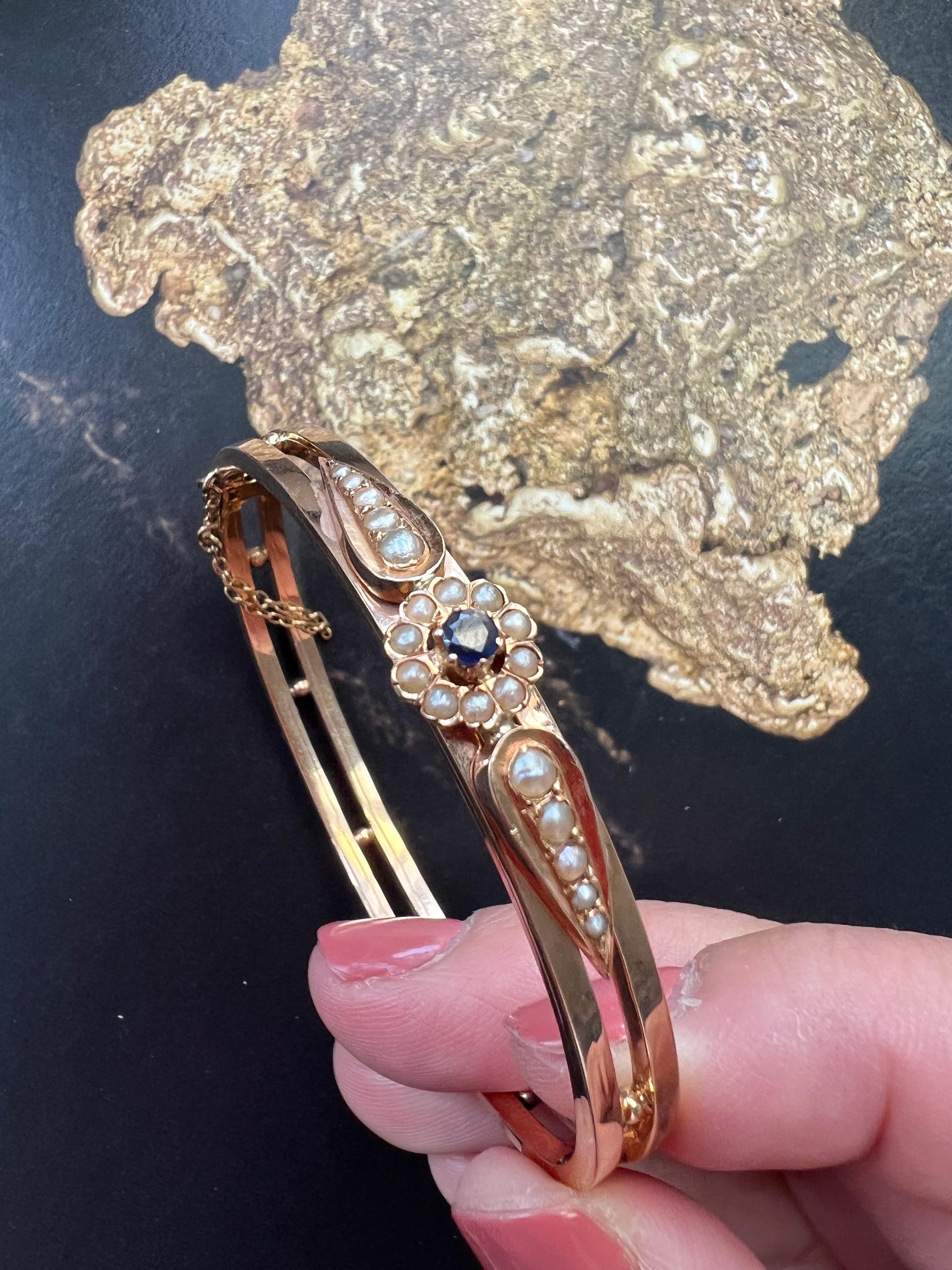 Deceptively simple yet undeniably elegant and feminine, this beautiful Victorian era 18K yellow gold bracelet captured our attention the first time we saw it.

The bracelet features a flower motif in the center, made of a blue sapphire surrounded by