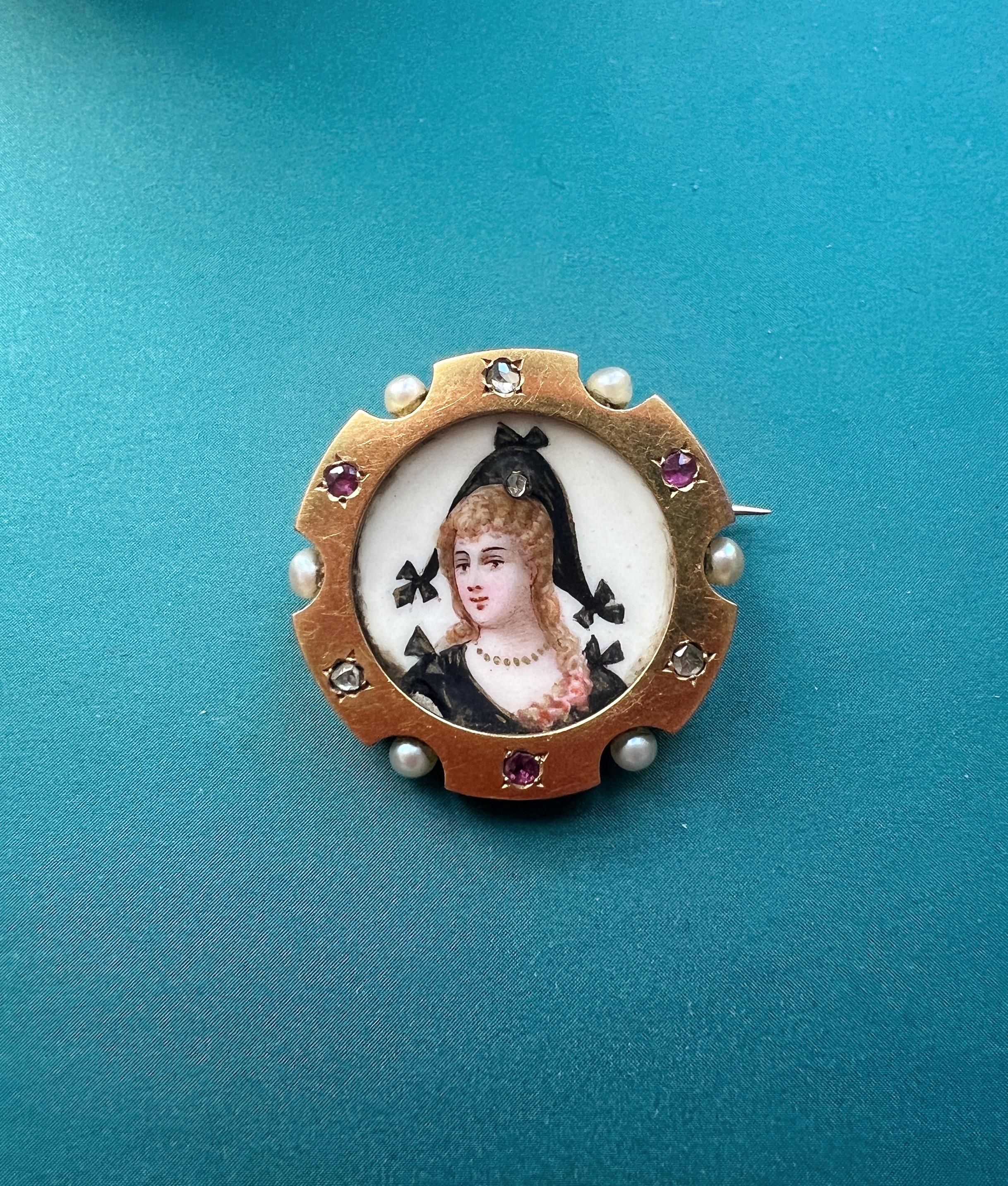 For sale a refined 18K gold bejewelled miniature portrait brooch, featuring a woman wearing an intriguing harlequin heat with a rose cut diamond on it. This type of couture is often seen in the Commedia dell’Arte.

The enemaled painting shows
