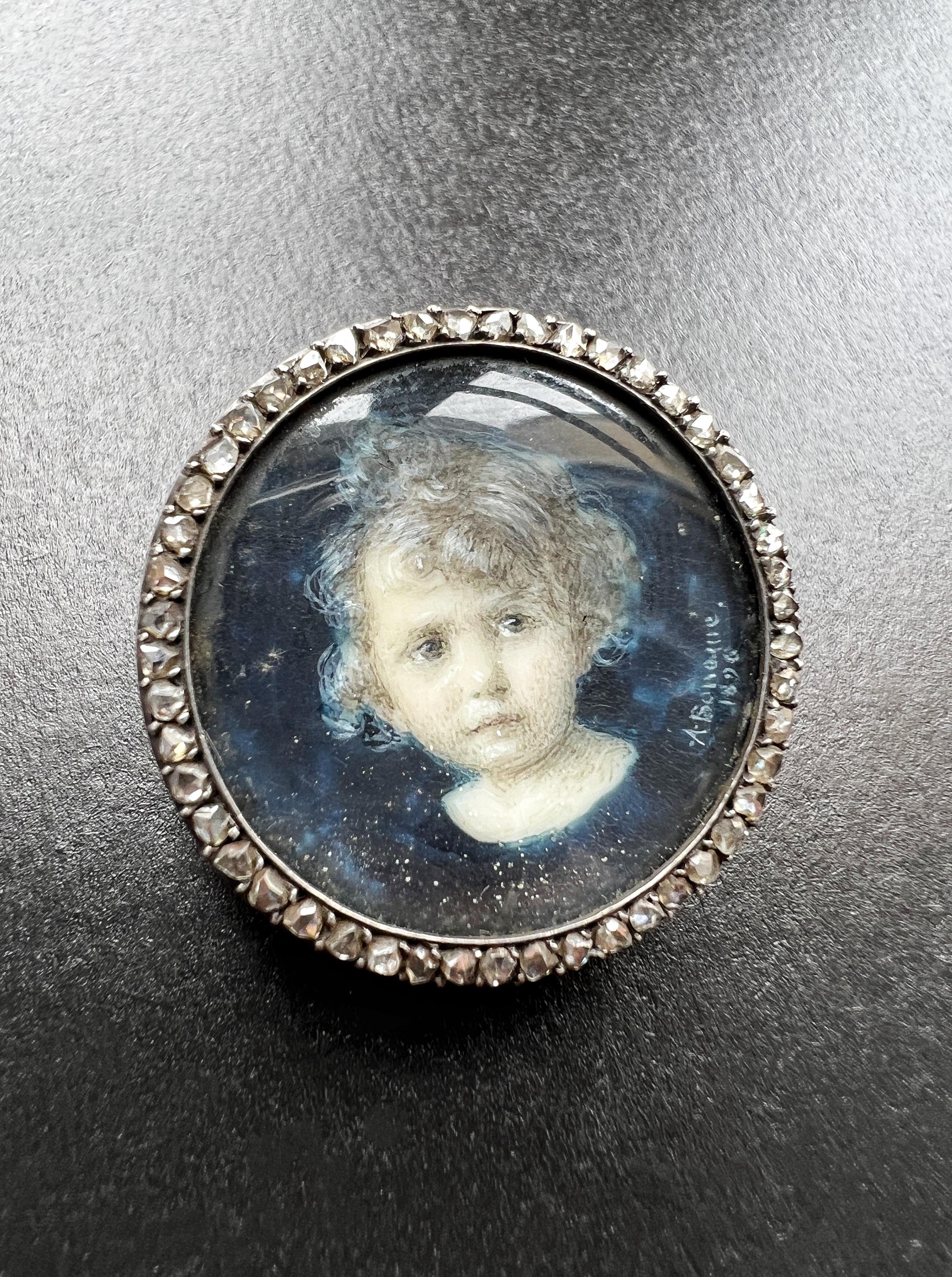 This Victorian era miniature portrait brooch is a stunning example of the artistry and craftsmanship of the time. The brooch features a young child, captured in an intricately detailed miniature portrait, set against a deep blue background. The