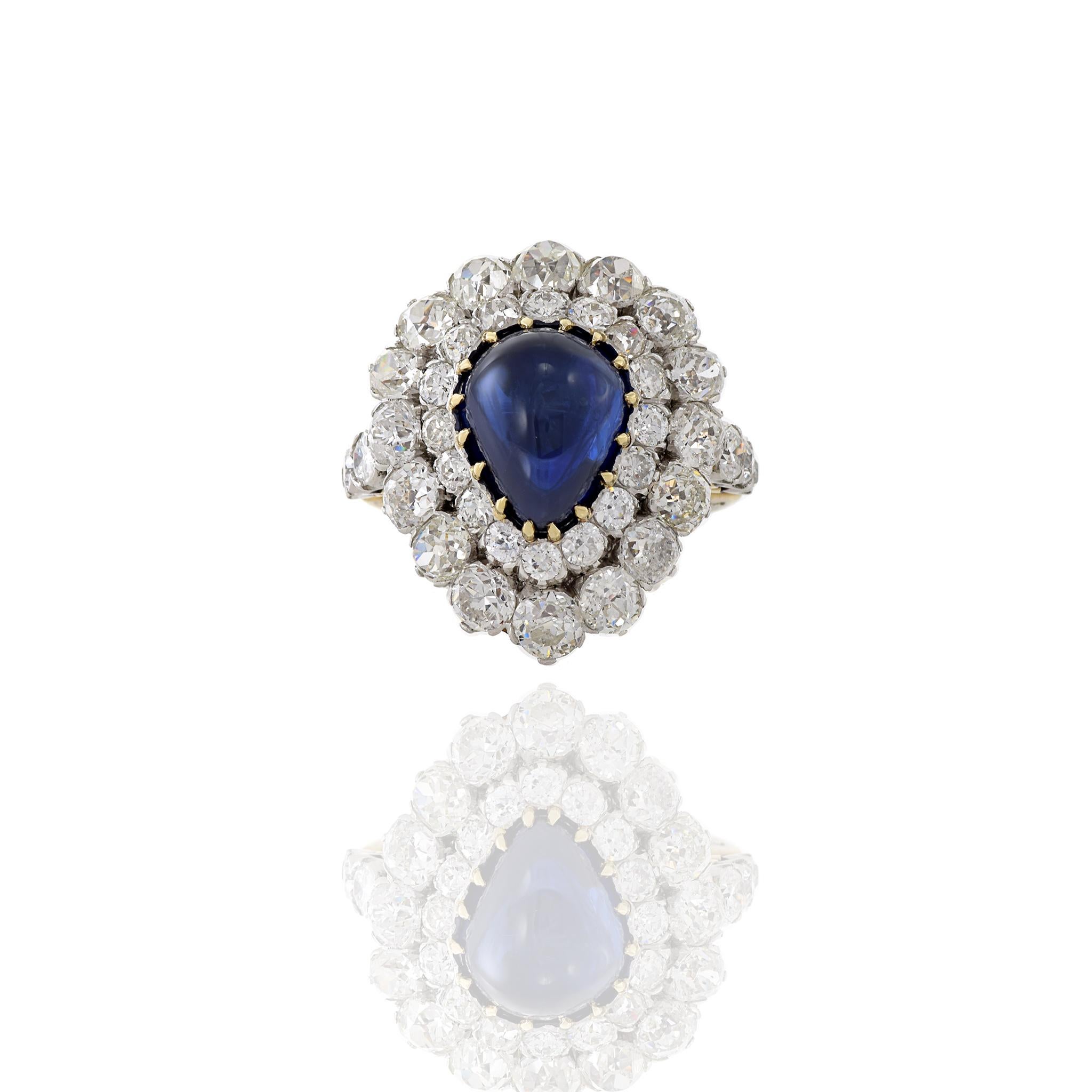 This Estate piece from the Victorian Era is set in 18KT yellow gold and platinum featuring a Blue Sapphire and diamonds. A cocktail ring consisting of one pear shaped cabochon genuine blue sapphire weighing 8.50CT surrounded by 5.30CT-TW old