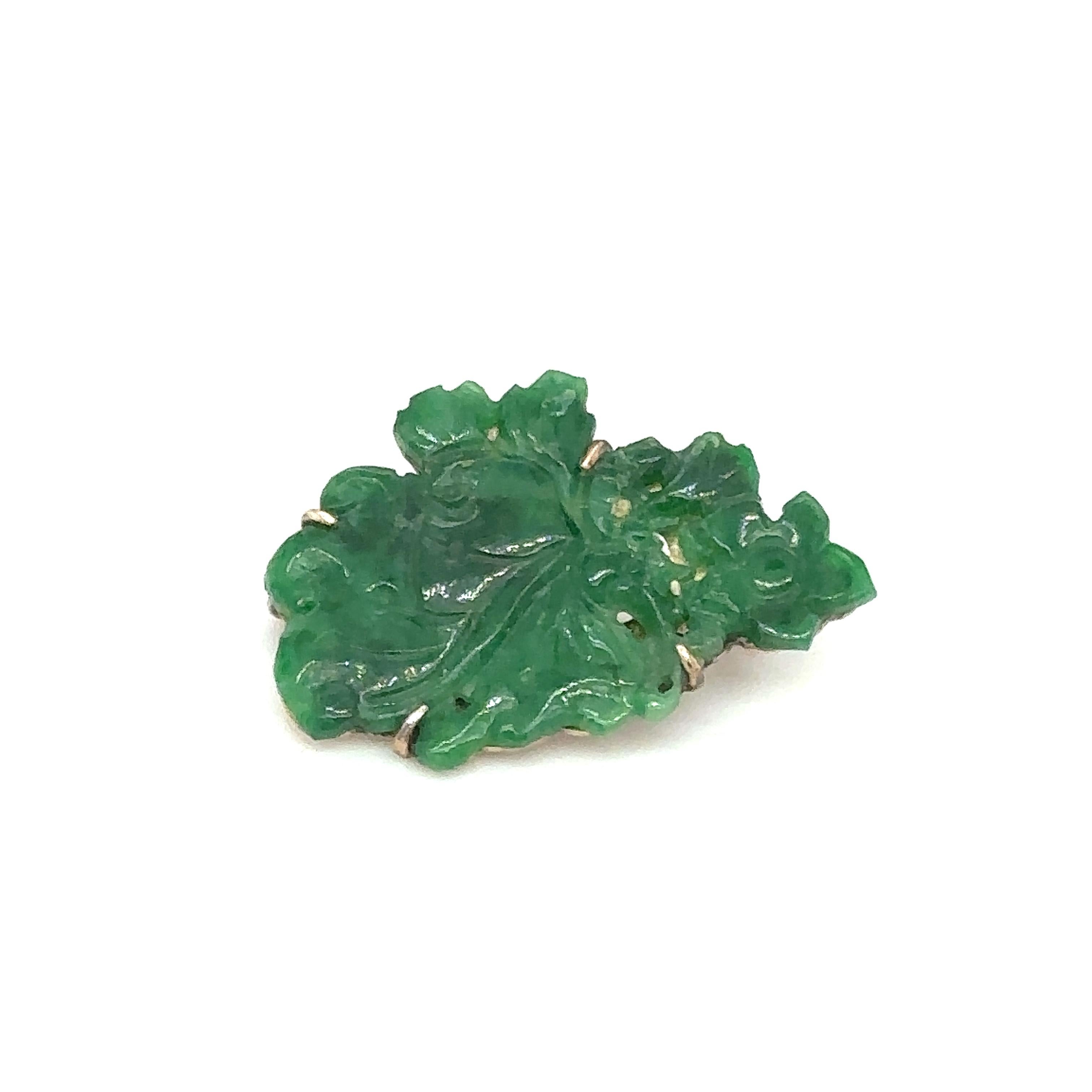 Item Details: This unique brooch dates from the late Victorian period and features a vibrant green jade carving in a foliate design.

Circa: 1890s
Metal Type: 14 Karat Yellow Gold
Weight: 3.2 grams 
Size: 1 inch approximately 