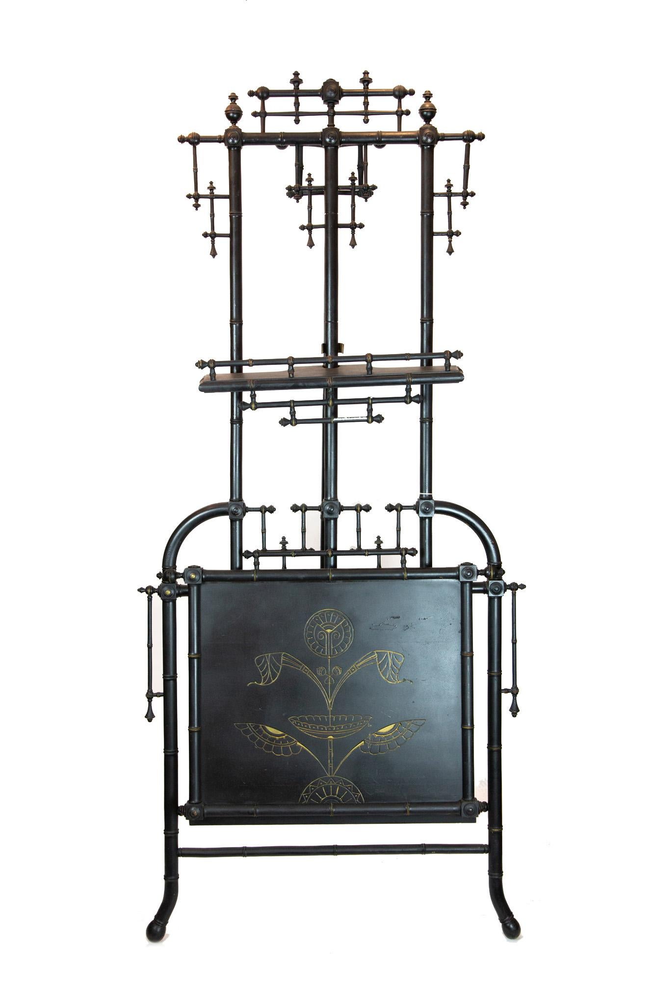 Victorian-era ebonized easel with folio. Decorated with glower design. Has adjustable easel shelf and folio opens and closes, attached by chain.