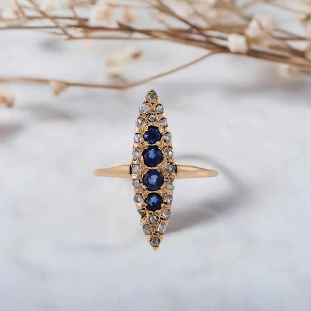 Victorian Era Marquise Shaped Sapphire and Diamond Ring. Adorned with 0.36ct-tw Round cut blue sapphires and 0.38ct-tw old mine cut diamonds, set in 10kt yellow gold, this ring is a true masterpiece. Its delicate design and intricate details are