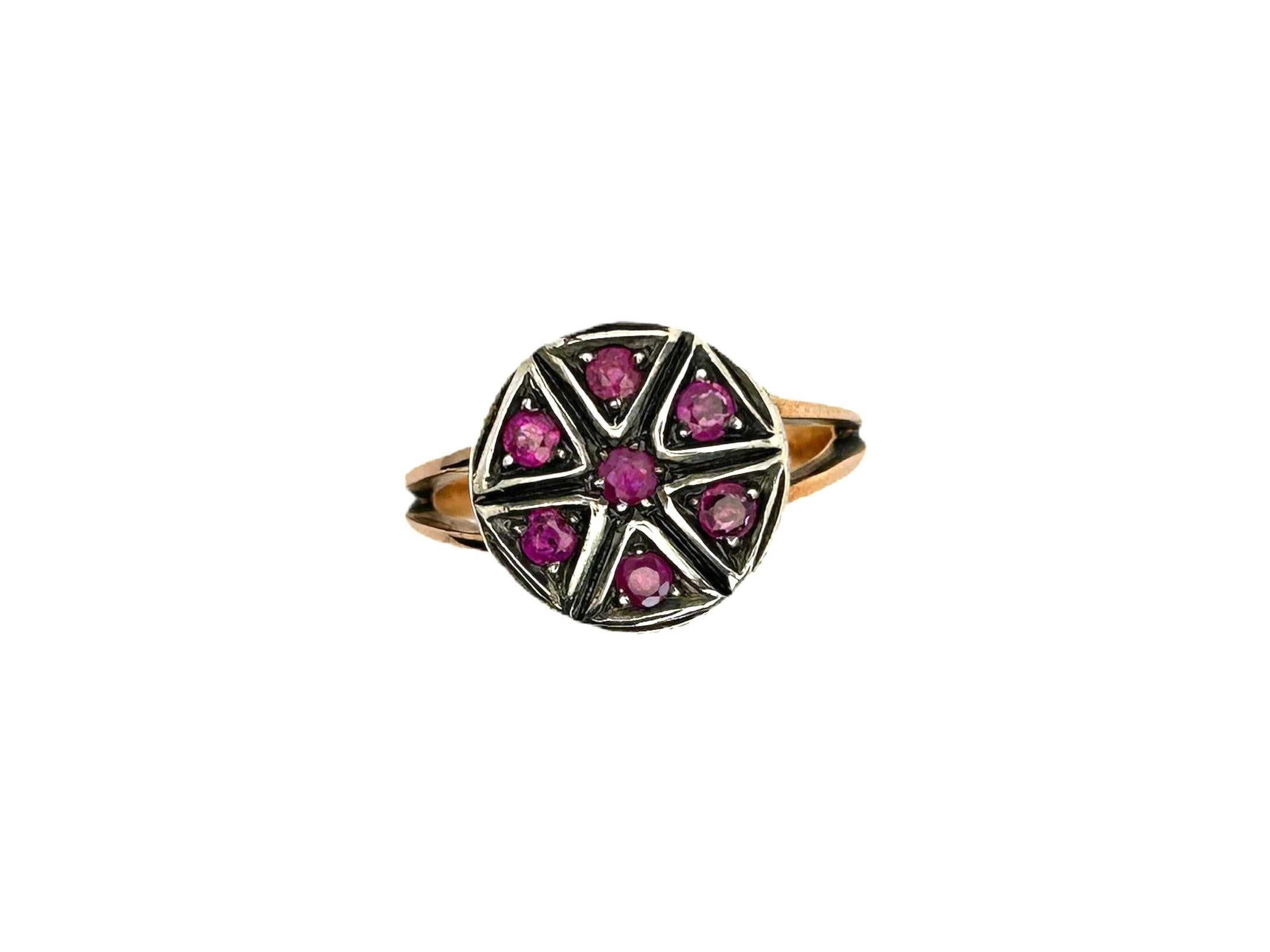 This Victorian era inspired ring is made in 9Kt pink gold and surrounded by a sterling silver round frame diameter 13mm.
It features 7 brilliant cut Rubies which gave a star pattern design at the center.

The combination of colors gives to this cool