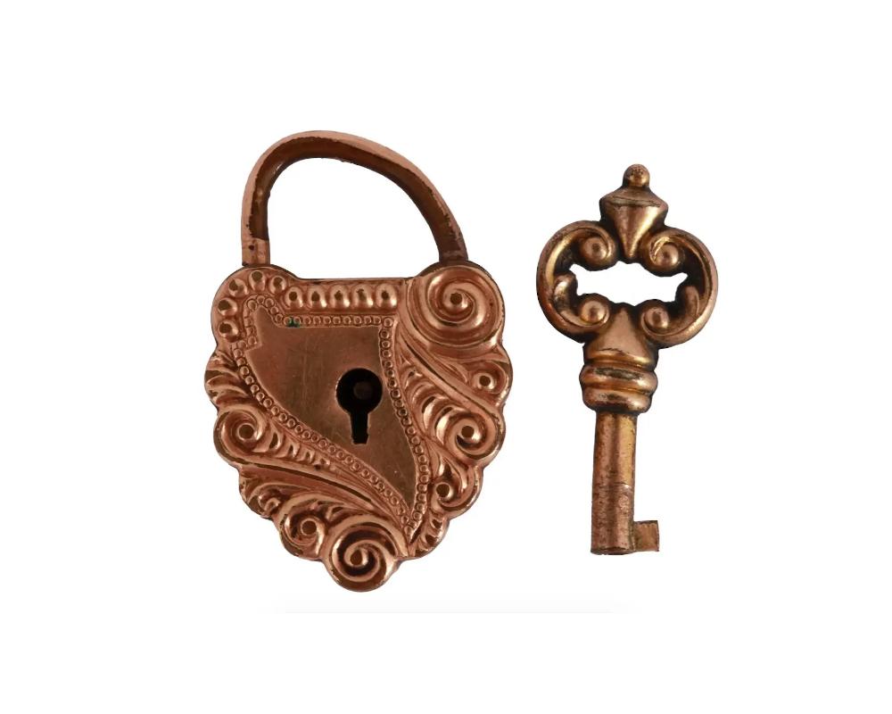 A Victorian era heart-shaped rose gold lock charm. The piece is decorated with ornamental relief. The lock comes with a matching key. Weight: 5 grams. Collectible Antique Vanity Items And Jewelry.

Dimensions: 1 x 5/8 in. All measurements are
